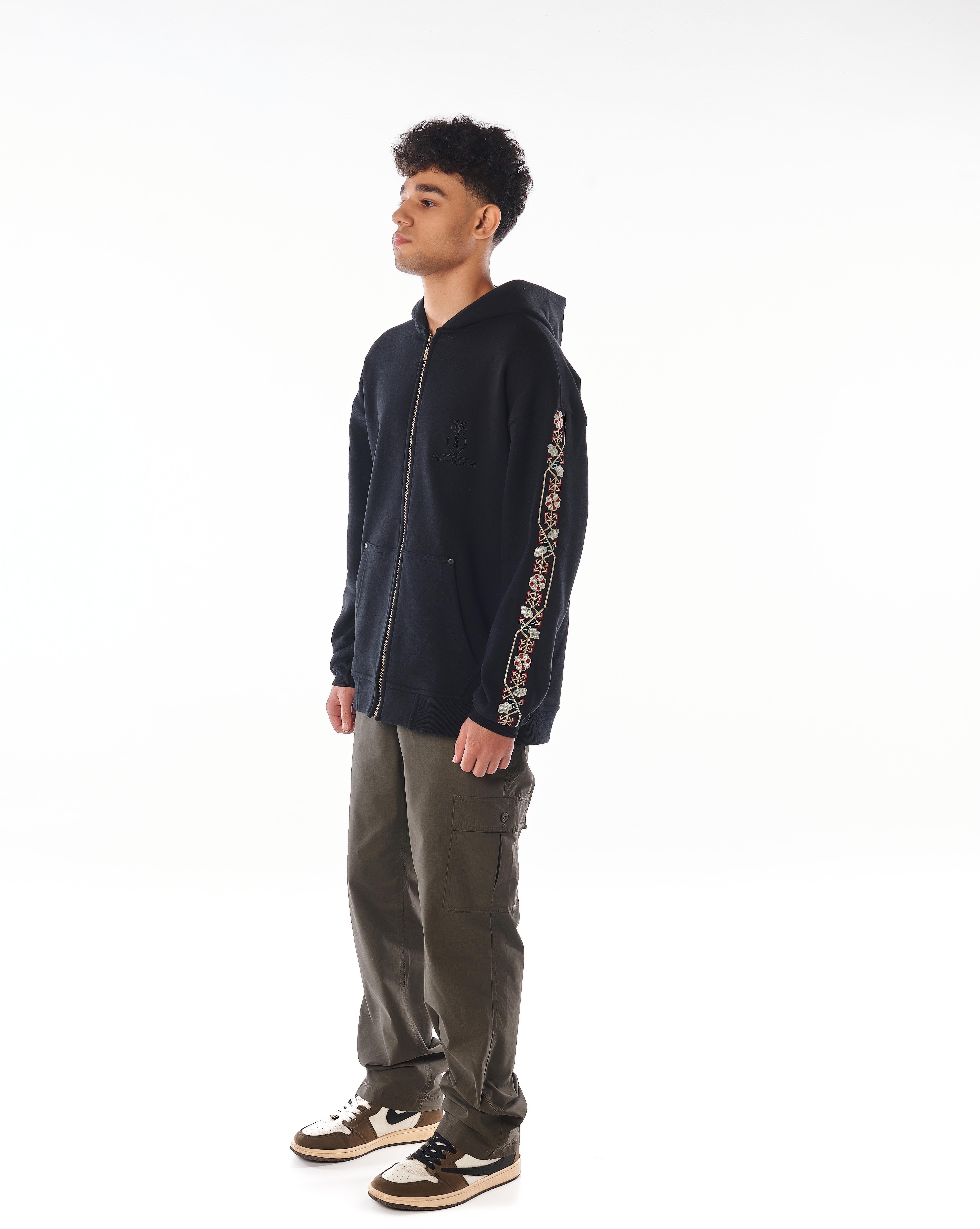 Culture Zip-Hoodie von MOE CHARLIE, seitliche Ansicht, Ärmel-Stickerei und goldener Reißverschluss sichtbar