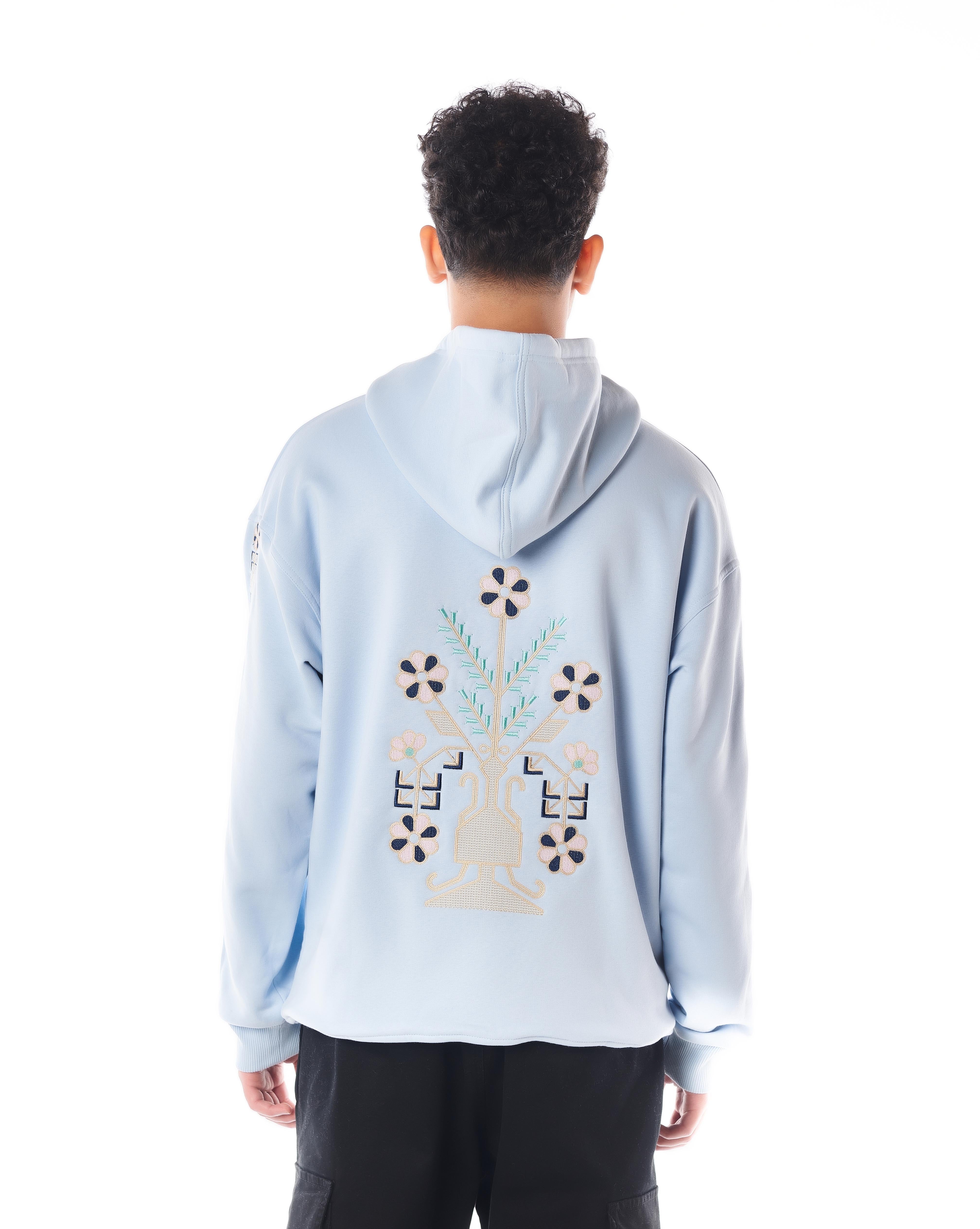 Rückenansicht MOE CHARLIE Culture Hoodie Hellblau, Blumen-Vasen-Stickerei in Beige und Navy auf dem Rücken