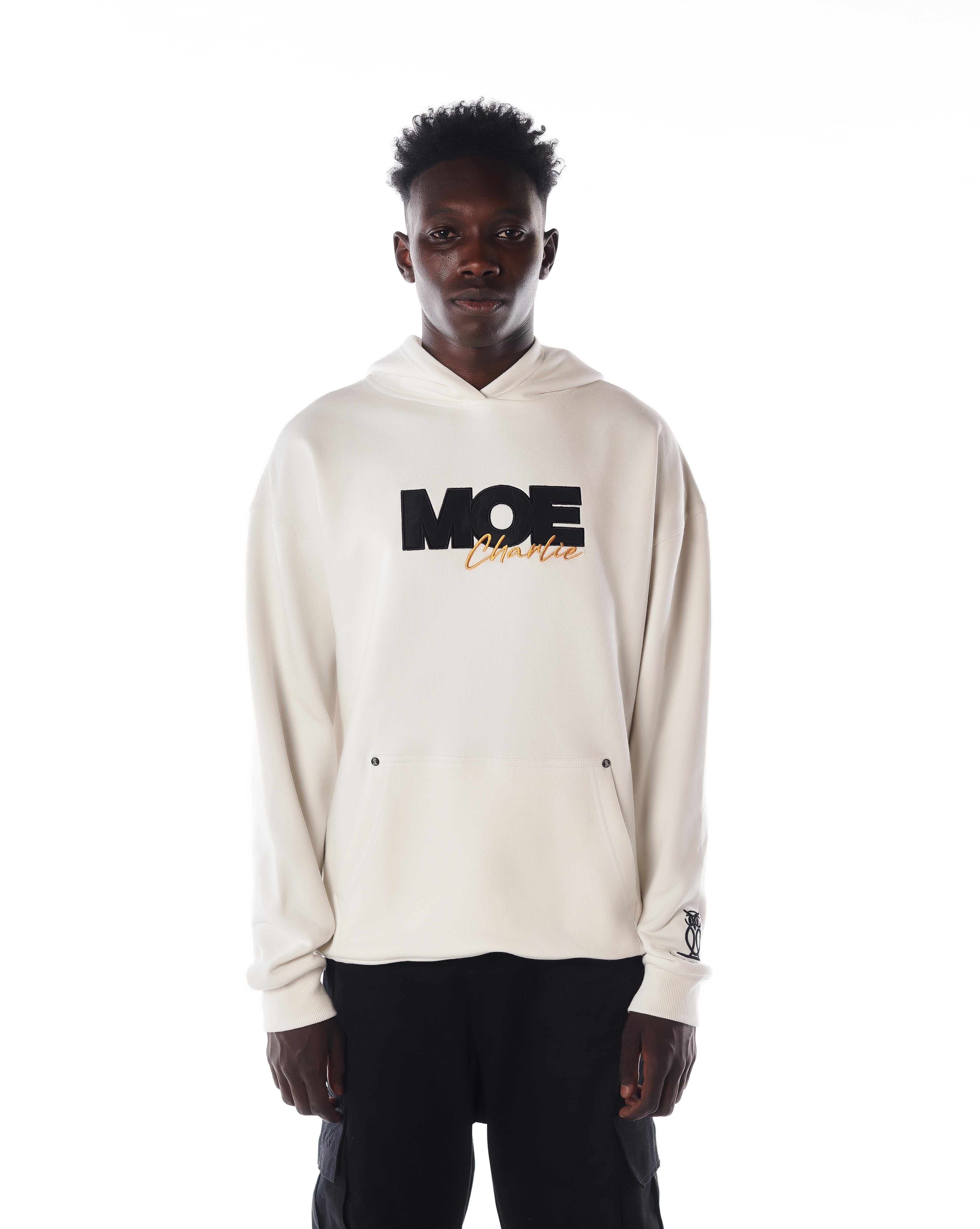 Ganzkörper-Frontansicht MOE CHARLIE Gold Passion Hoodie, cremefarbene Farbgebung, Eulen-Logo am Handgelenk