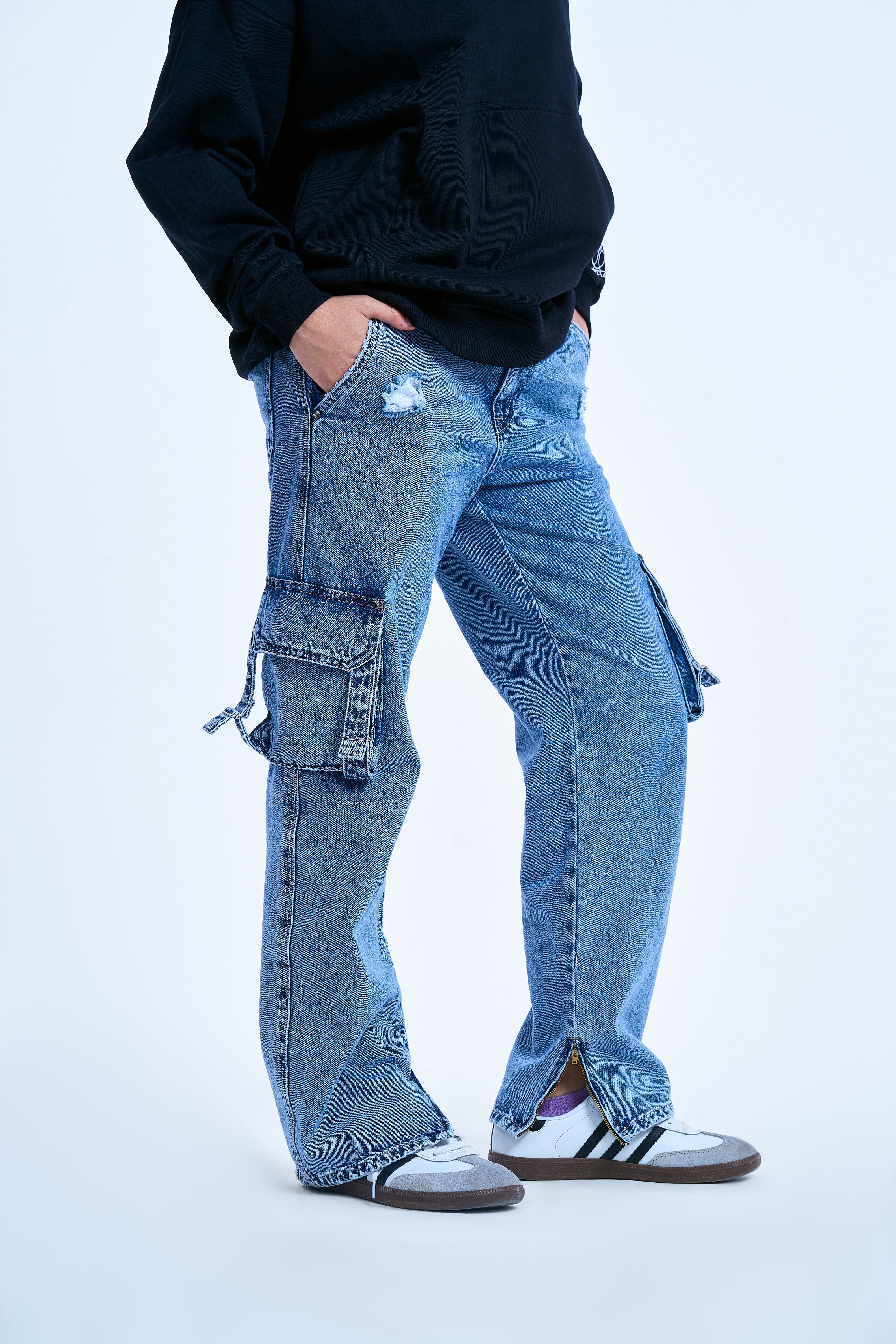 MOE CHARLIE Ice Cargo Denim vorne-seitlich – eisgewaschenes Hellblau, geöffneter Saum-Zipper, Adidas Samba Sneakers
