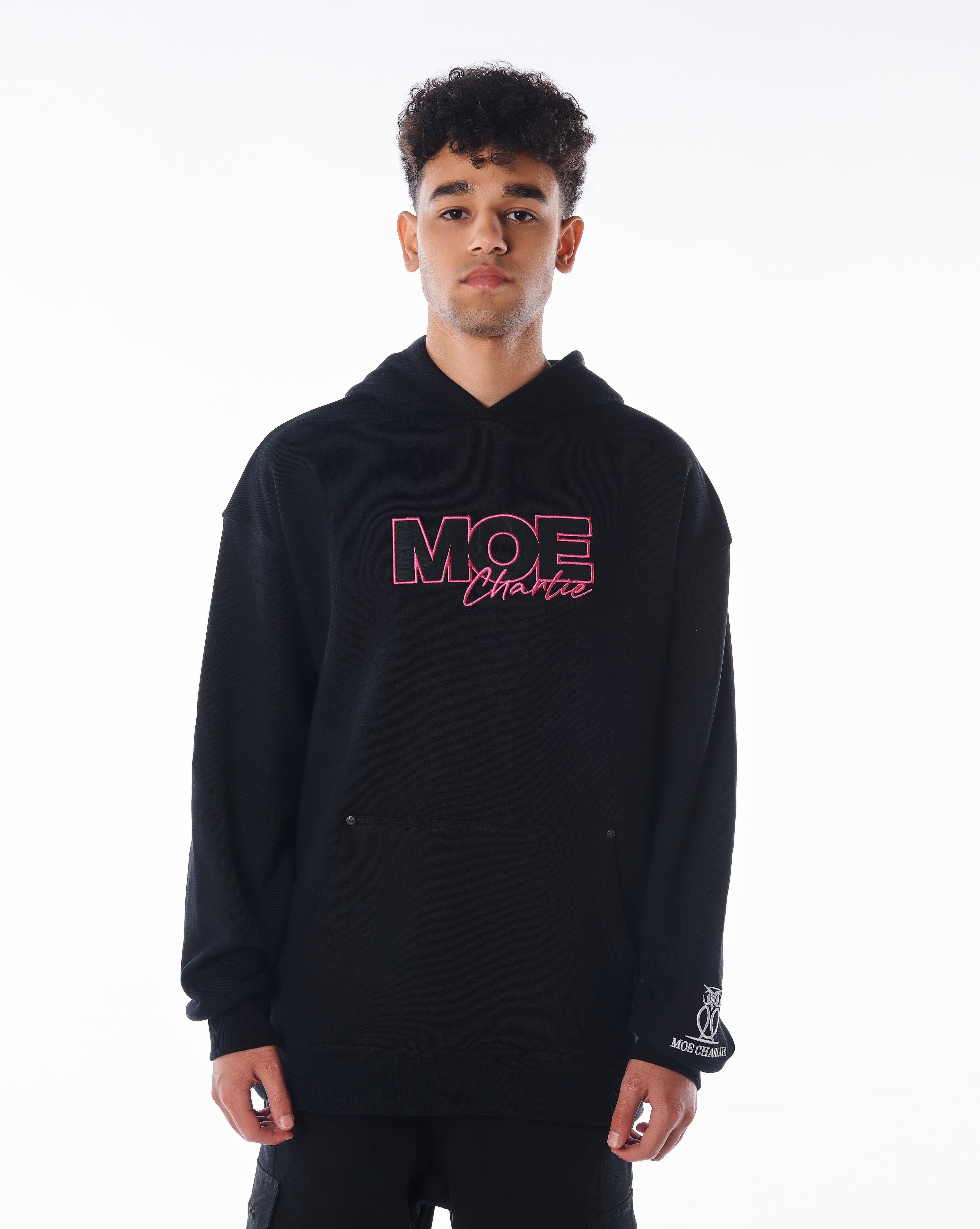 Frontansicht MOE CHARLIE Pink Passion Hoodie in Schwarz, pinke Logo-Stickerei auf Brust, Eulen-Logo am Ärmelabschluss
