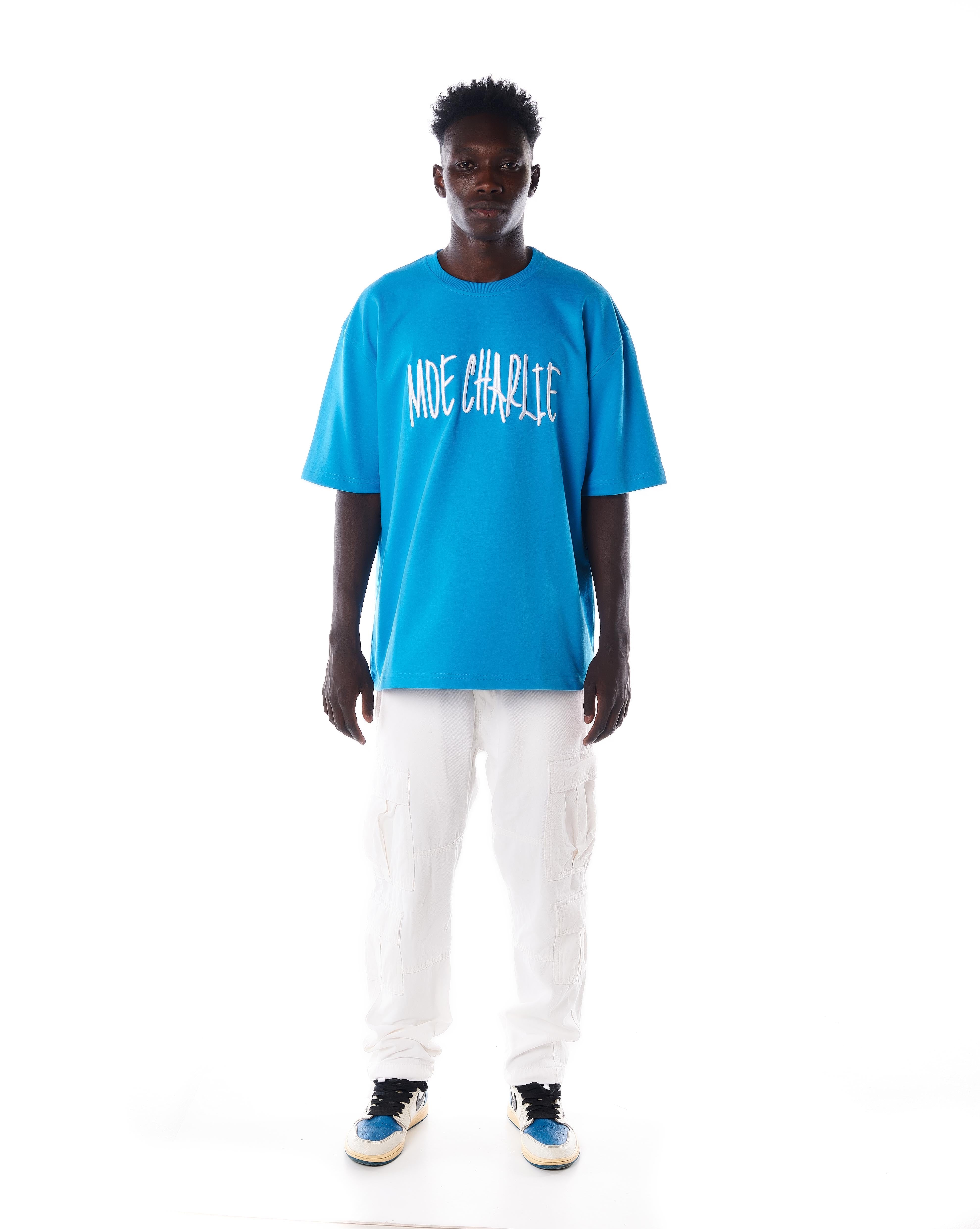 Frontansicht MOE CHARLIE Night Life T-Shirt in Azure-Blau, weißer Puff-Schriftzug auf der Brust, weiße Cargo-Hose