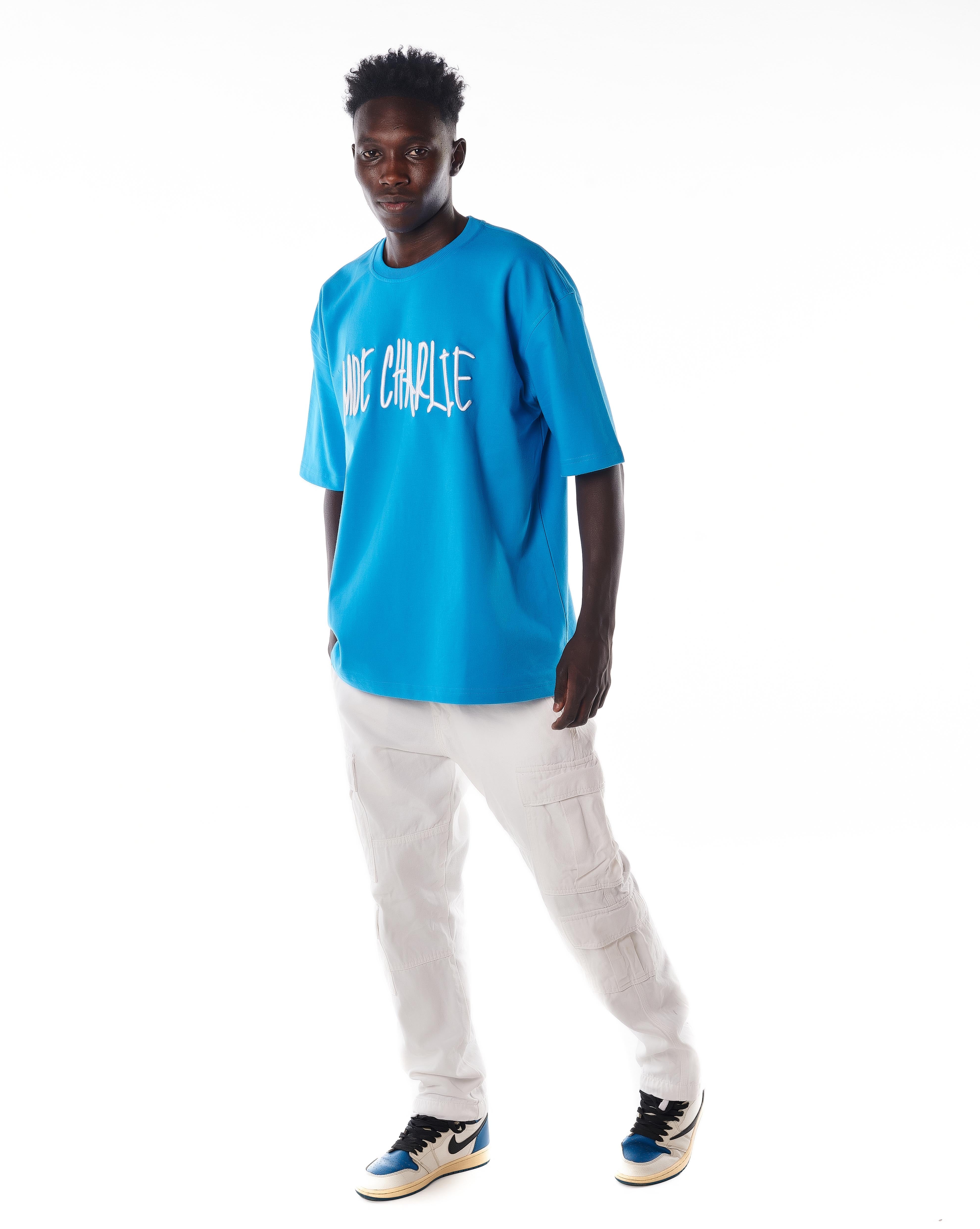Ganzkörper-Frontansicht MOE CHARLIE Night Life T-Shirt, azurblau mit weißer Cargo-Kombination, entspannte Pose