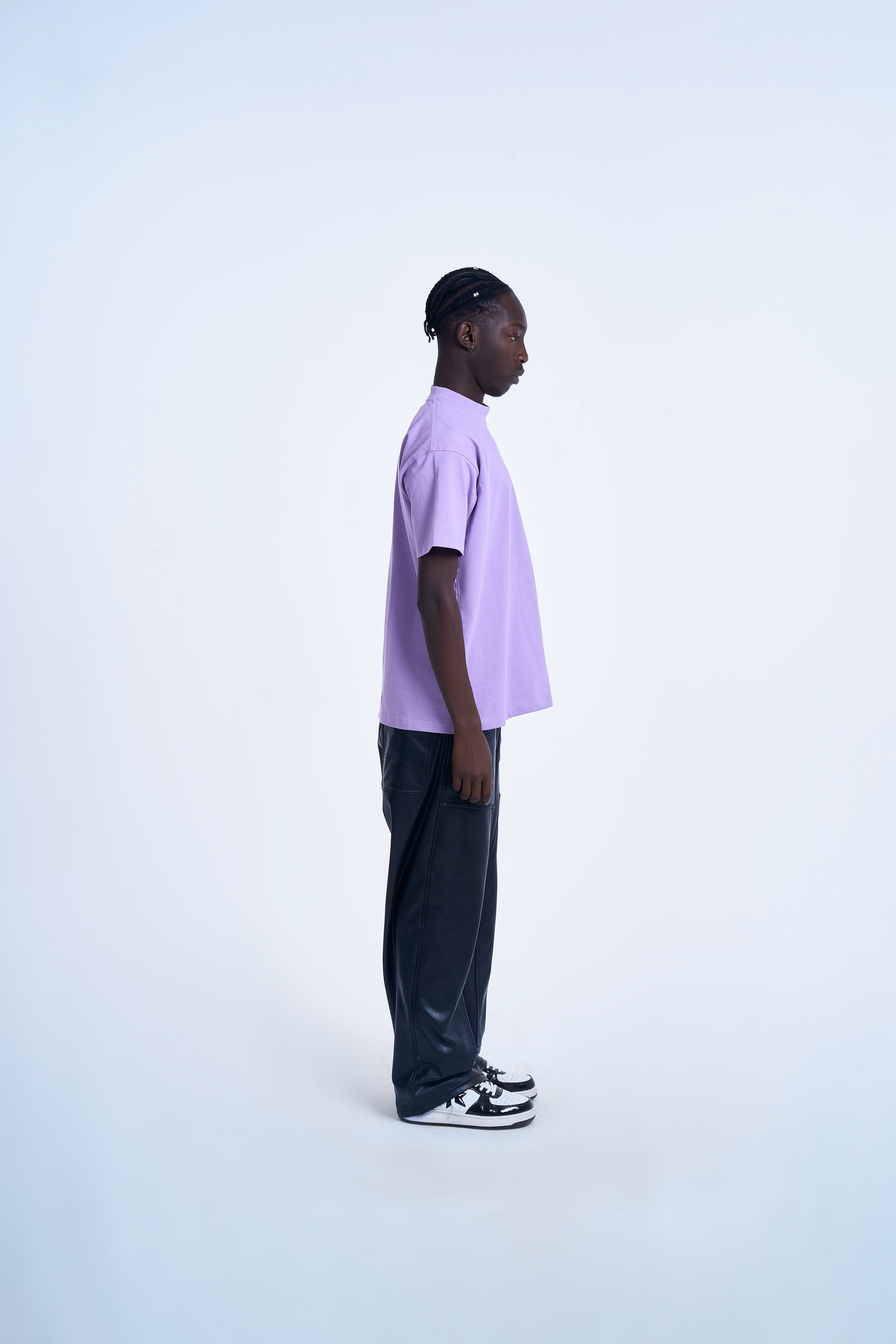 MOE CHARLIE Lavendel T-Shirt Seitenansicht rechts – cleaner Schnitt, schwarze Lederhose und schwarze Sneakers