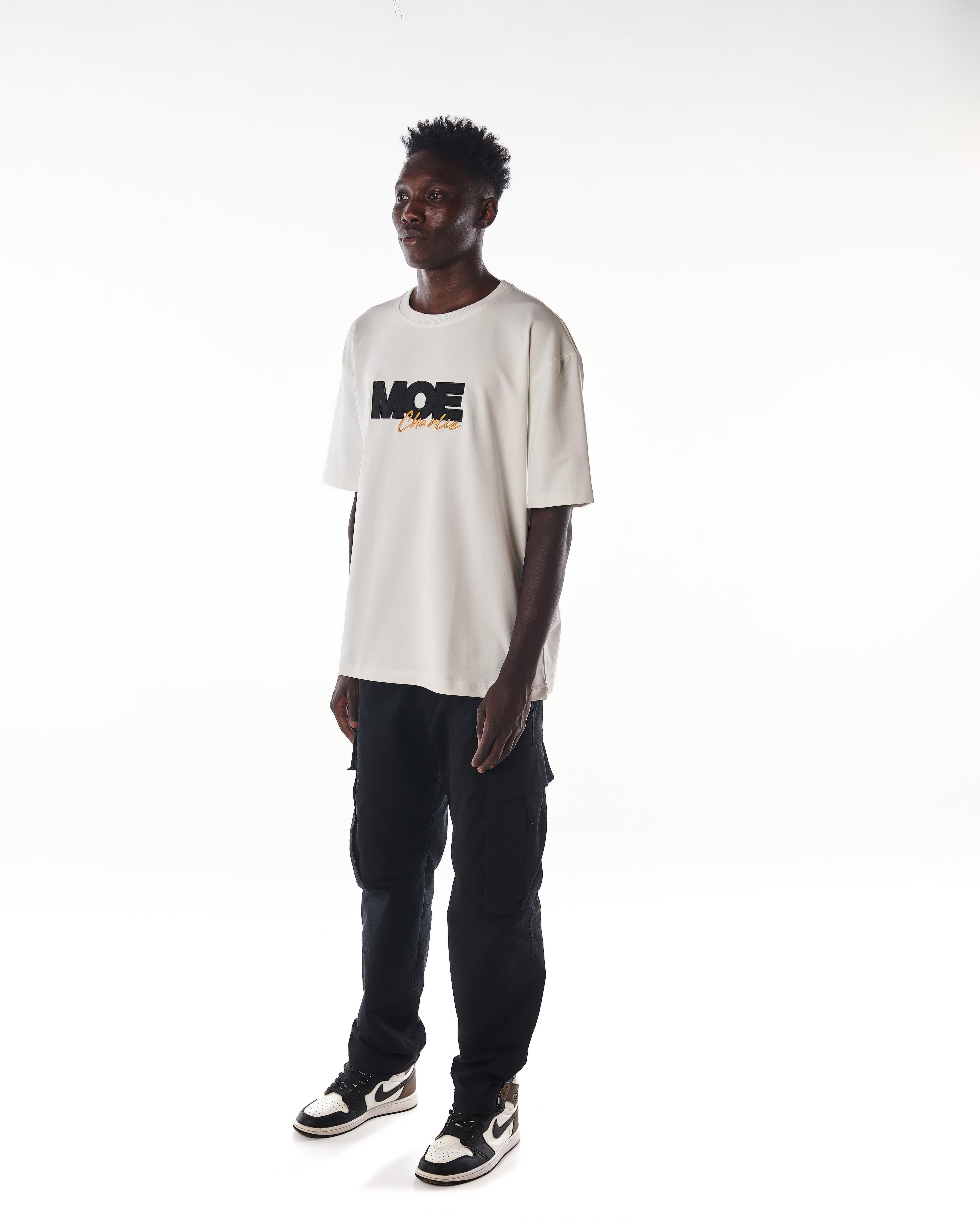 Dreiviertelansicht links MOE CHARLIE Gold Passion T-Shirt, Frontprint seitlich, Blick zur Seite, Jordan Sneakers
