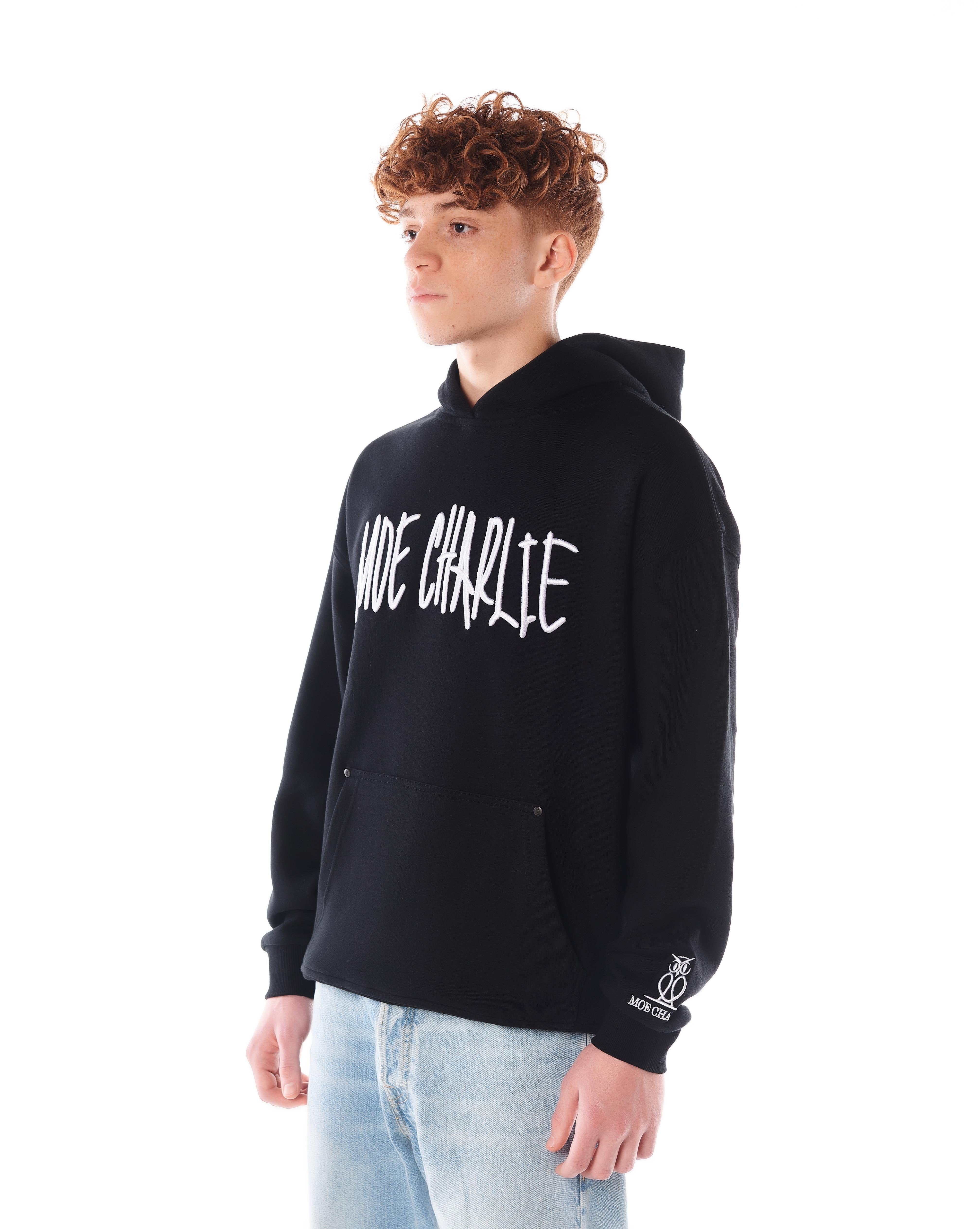 Night Life Hoodie in Schwarz, seitliche Dreiviertelansicht, MOE CHARLIE Graffiti-Stickerei von der Seite sichtbar