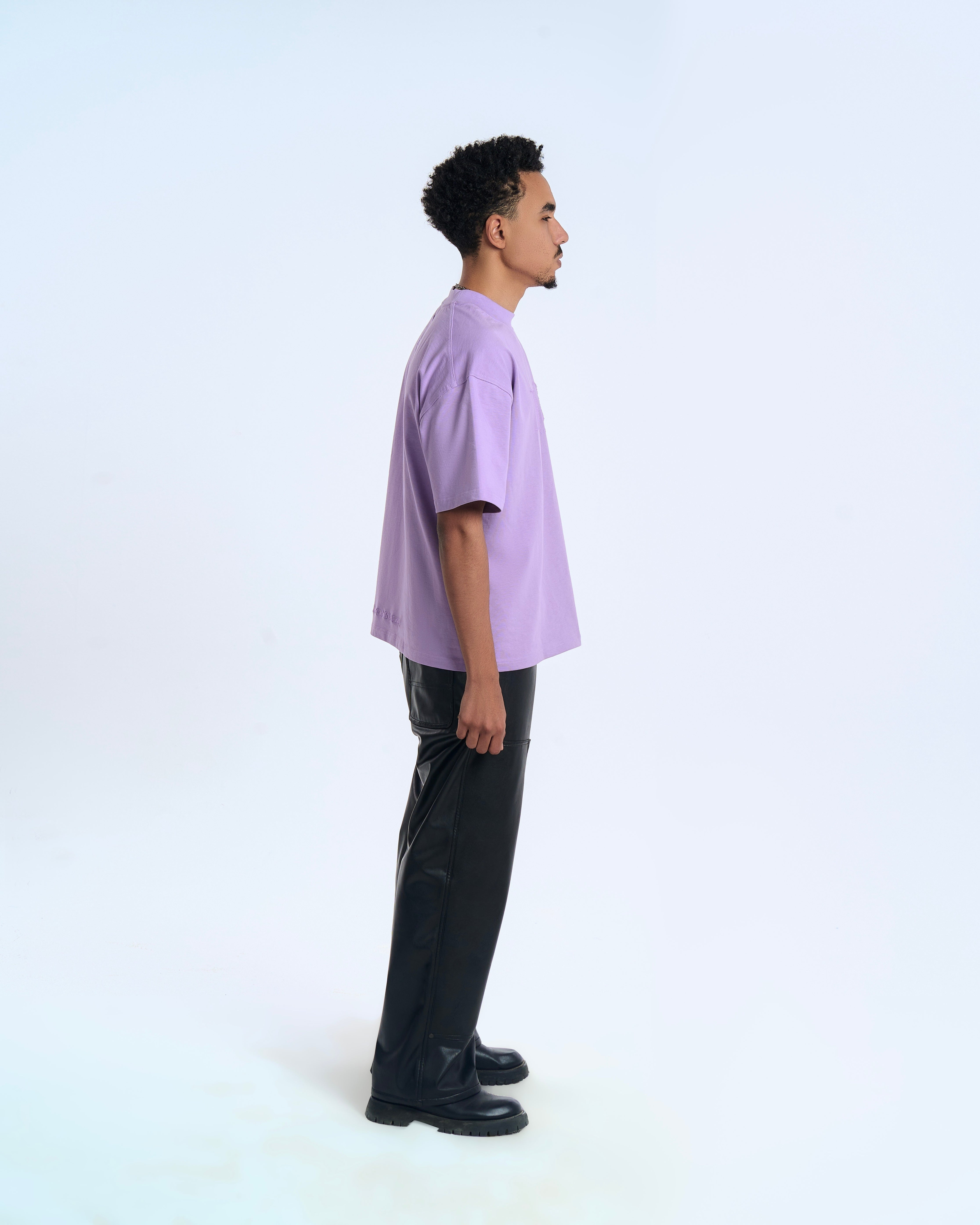 MOE CHARLIE Born In Exile T-Shirt Lavendel – Seitenansicht rechts, Oversize-Silhouette, schwarze Lederhose