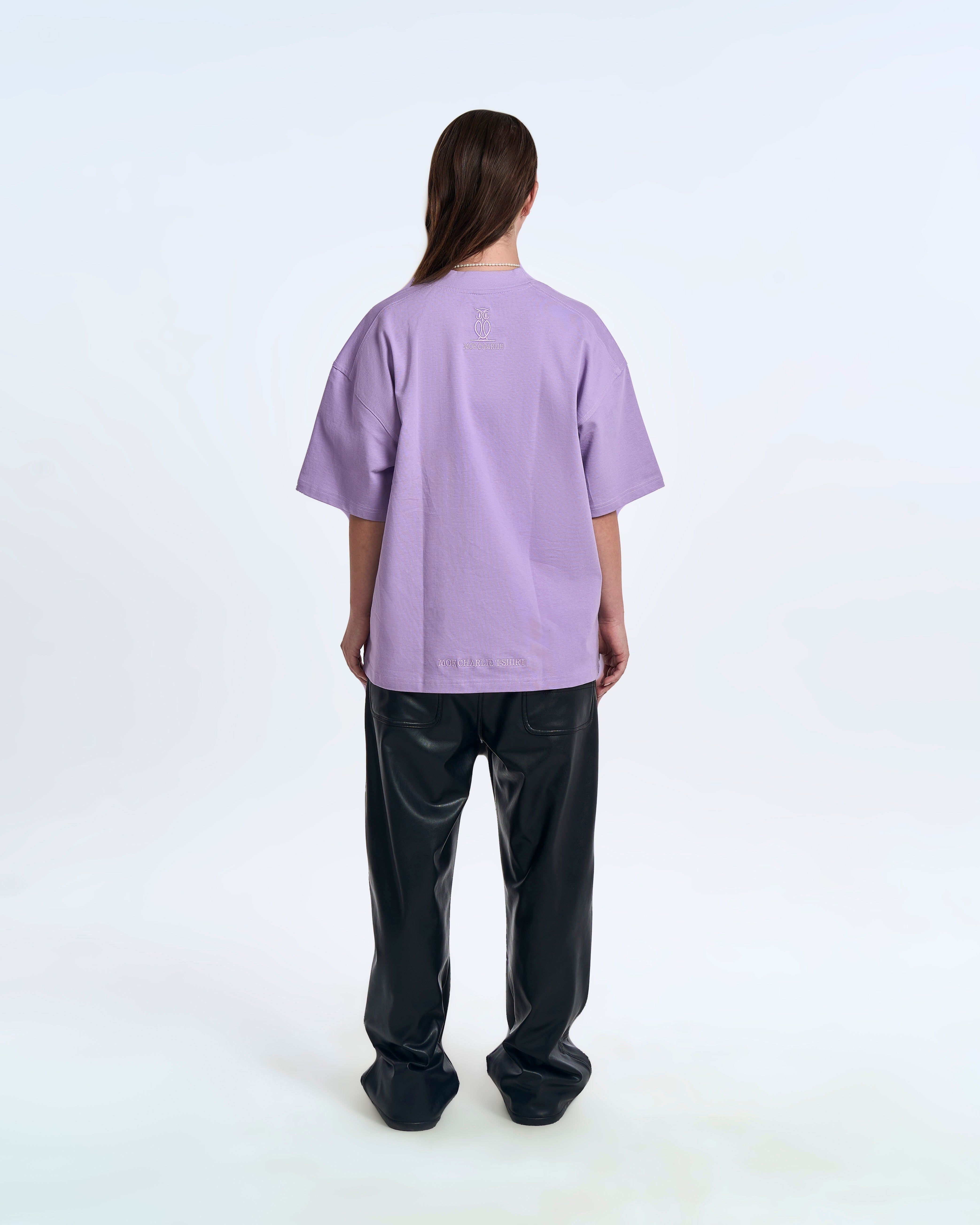 MOE CHARLIE Born In Exile T-Shirt Lavendel – Rückenansicht Damenmodel, Eulen-Logo und Saum-Stickerei