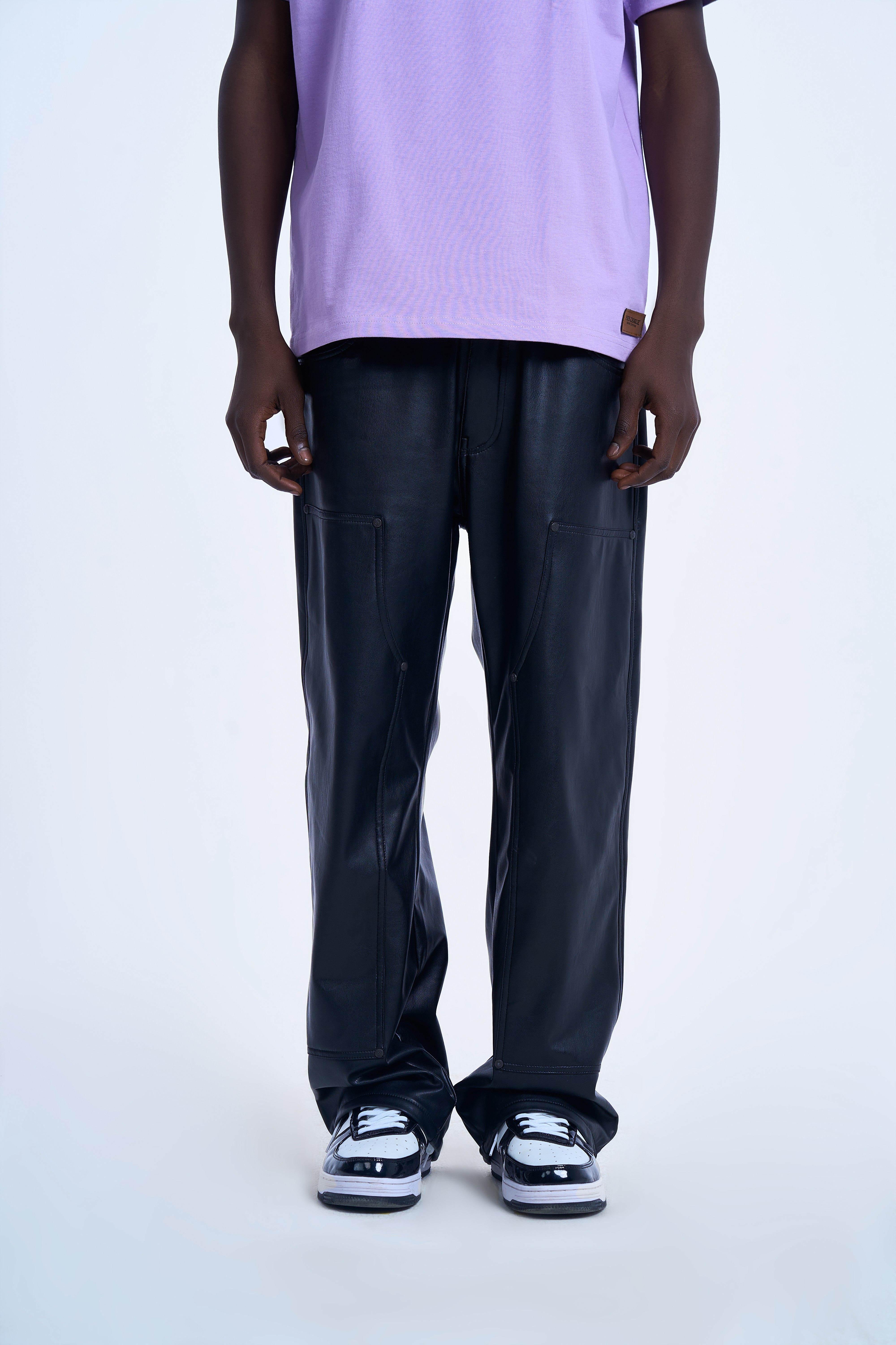 MOE CHARLIE Carpenter Leather Pants Schwarz, Frontansicht maennlich, weite Passform, lila T-Shirt, Sneaker