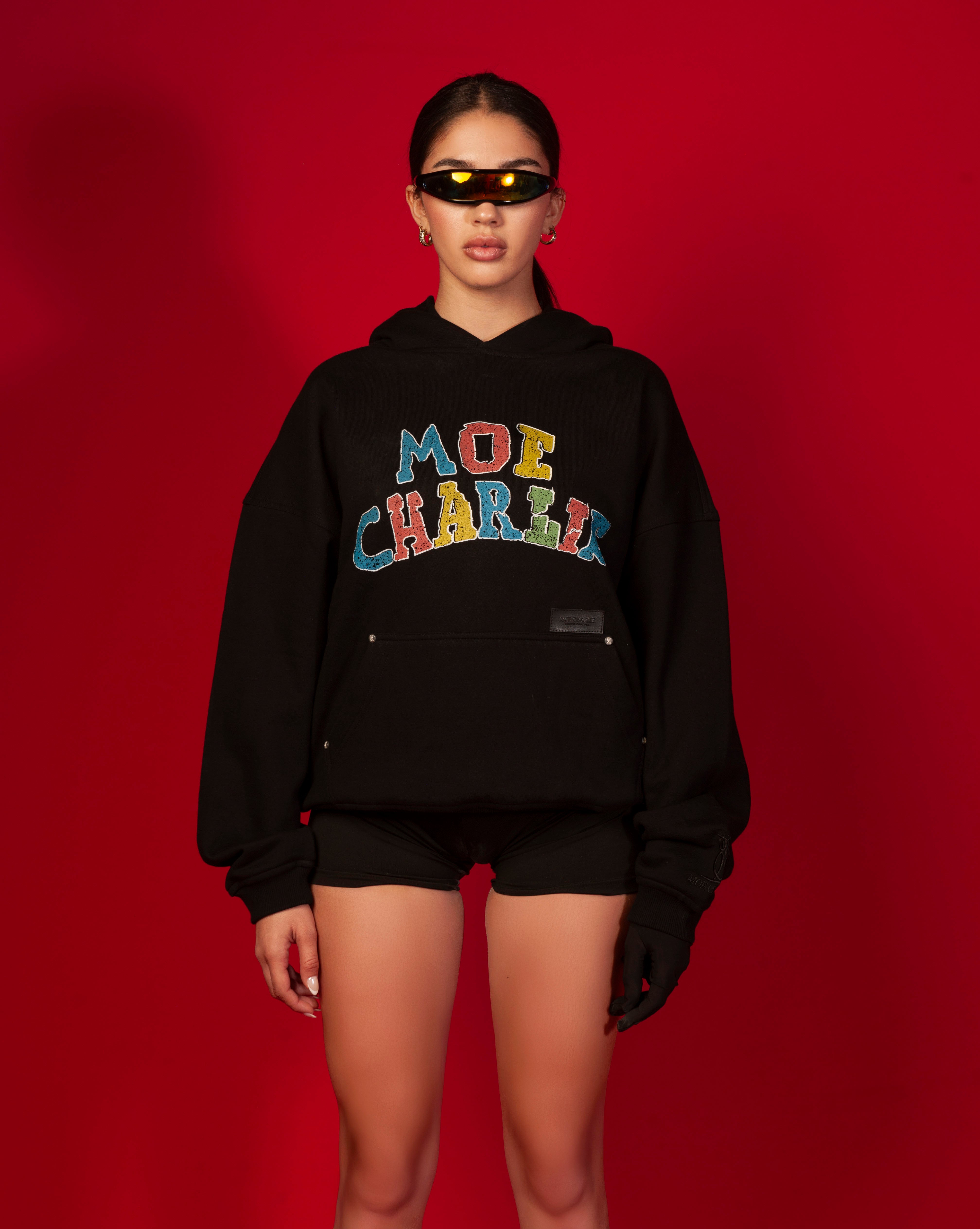 MOE CHARLIE Google Hoodie, weiblich Frontansicht, Kapuze unten, orangefarbener Visor, Hoop-Ohrringe