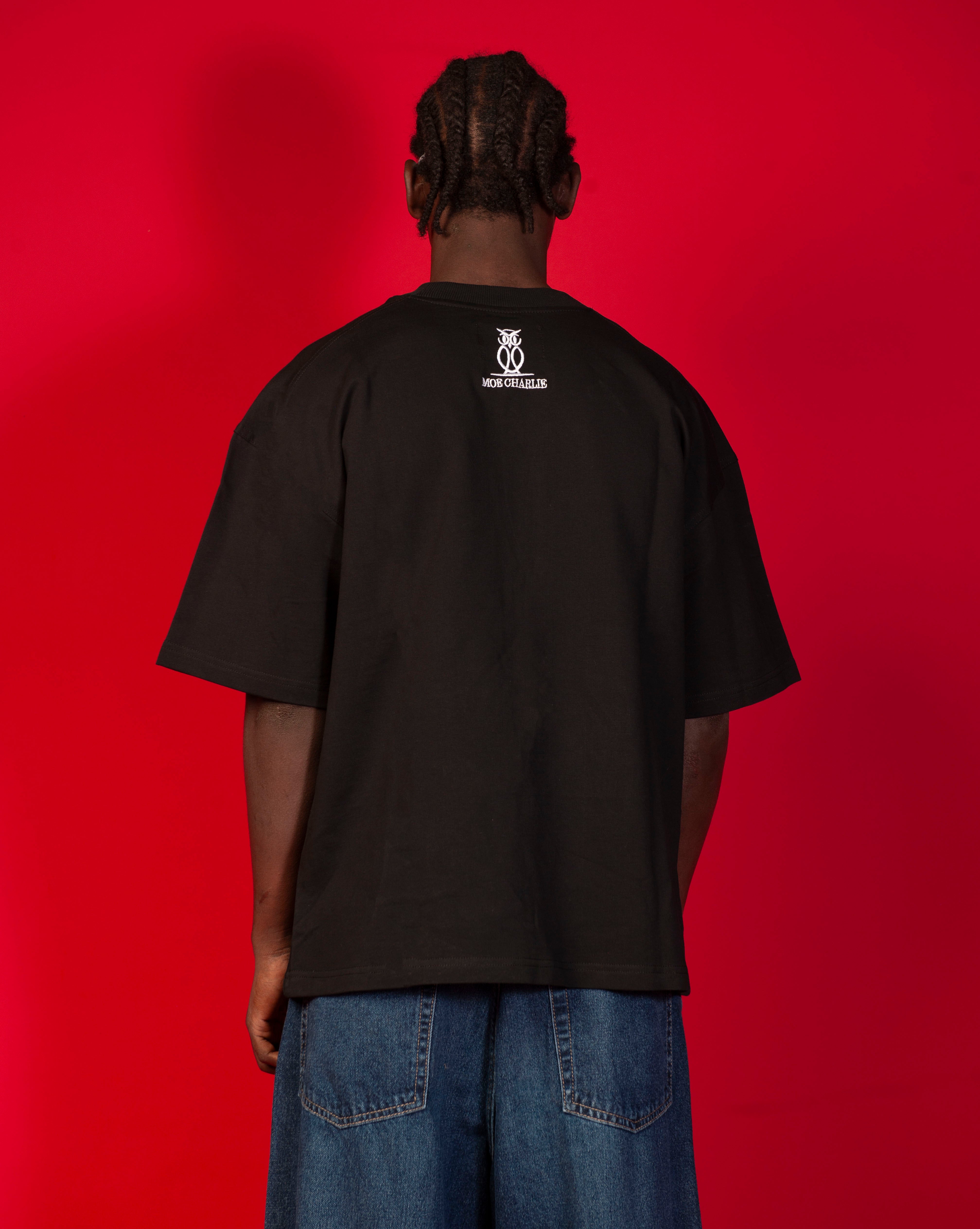 Rueckenansicht Patience T-Shirt MOE CHARLIE, saubere schwarze Rueckseite mit weissem Owl-Logo und CHARLIE-Schriftzug
