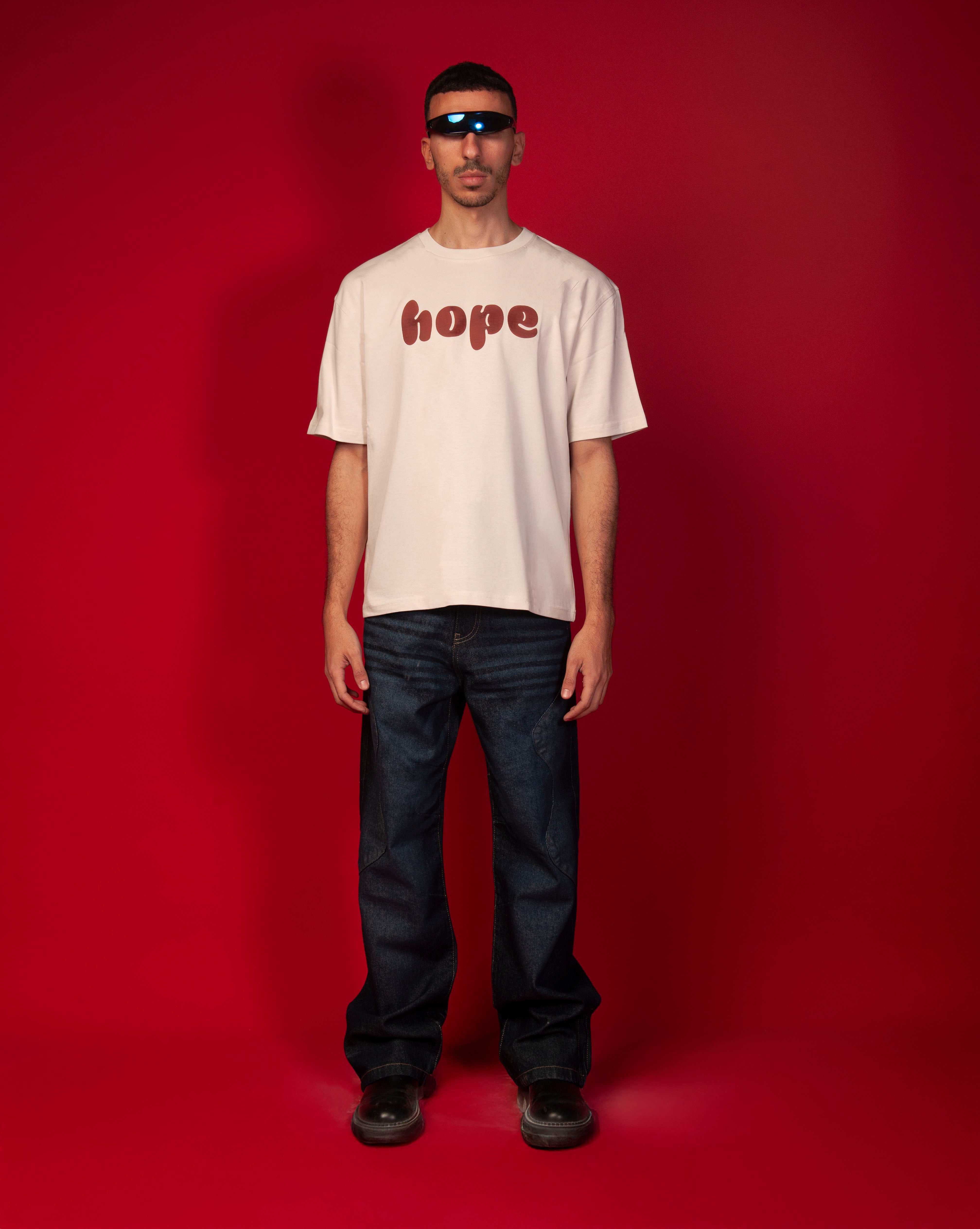Hope T-Shirt MOE CHARLIE, Frontansicht Ganzkoerper maennlich, hope-Print in Terrakotta, dunkle Navy-Jeans