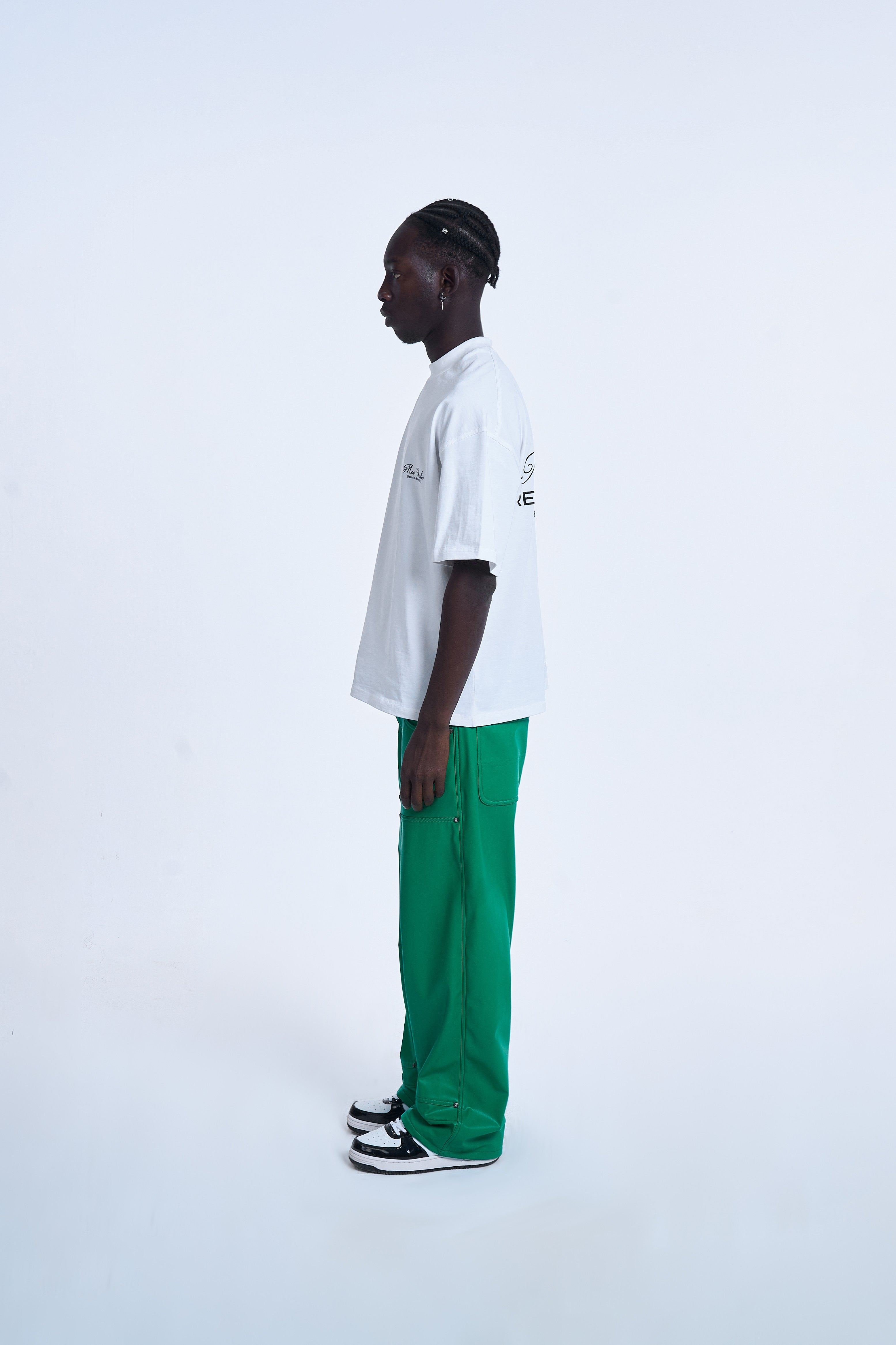 Seitenansicht MOE CHARLIE Ready To Die Shirt Weiß – Rückenprint seitlich erkennbar, grüne Lederhose, Air Jordan