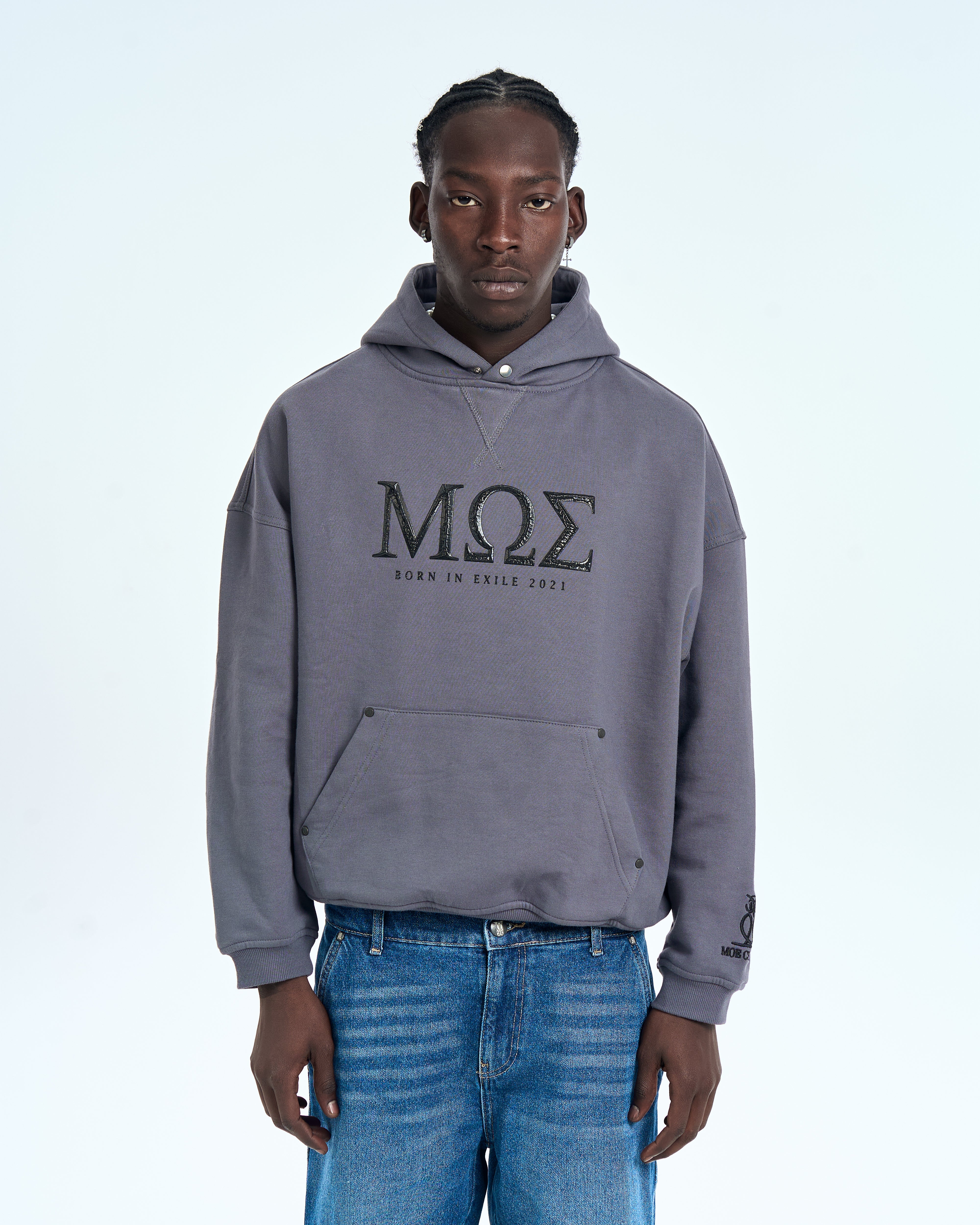 MOE CHARLIE Born in Exile Hoodie Grau, Frontansicht maennlich, MOE-Print und Kaenguru-Tasche, Cargo-Jeans