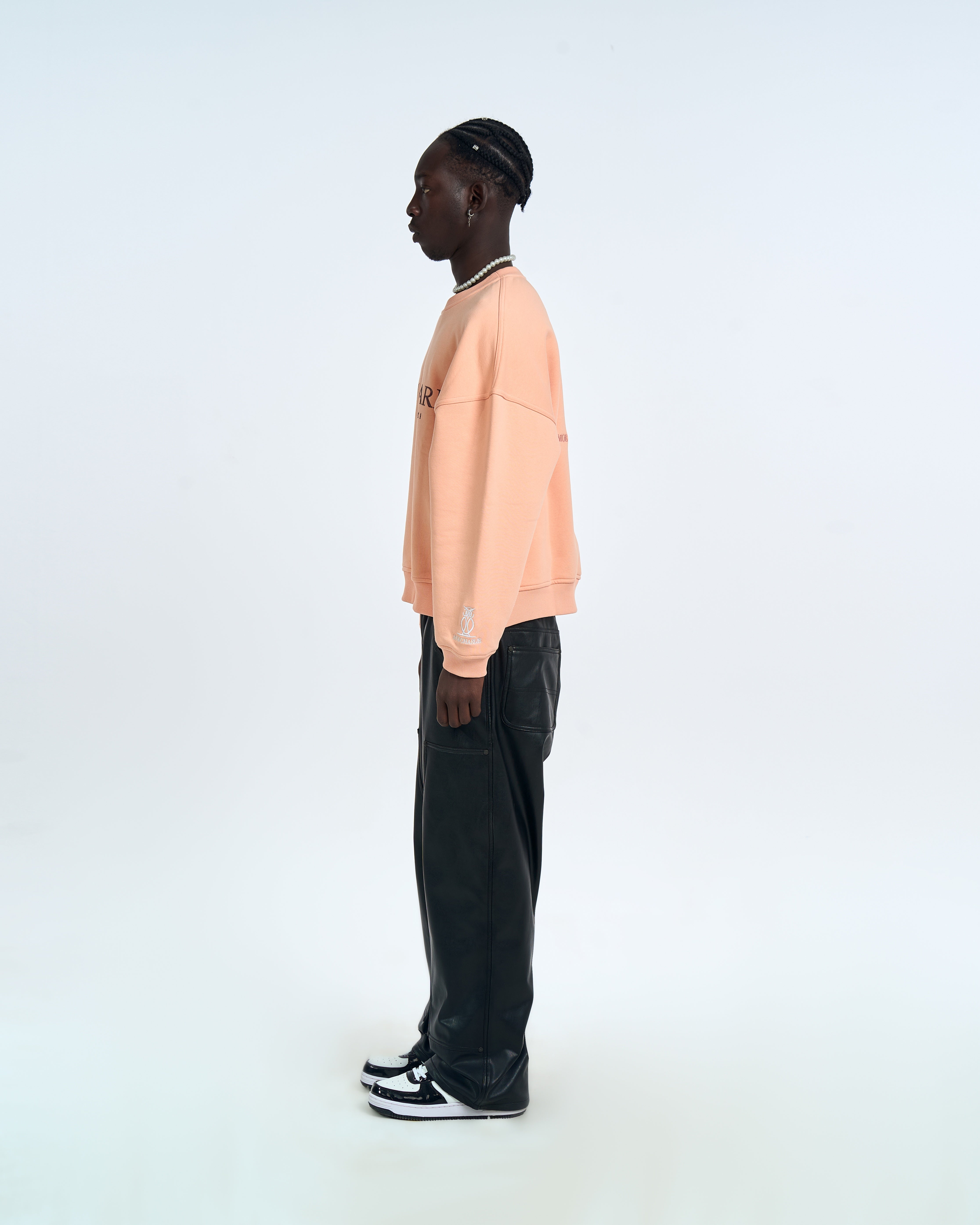 MOE CHARLIE Born In Exile Sweater Peach – Seitenansicht rechts Herren, Eulen-Logo auf Ärmelcuff, schwarze Lederhose