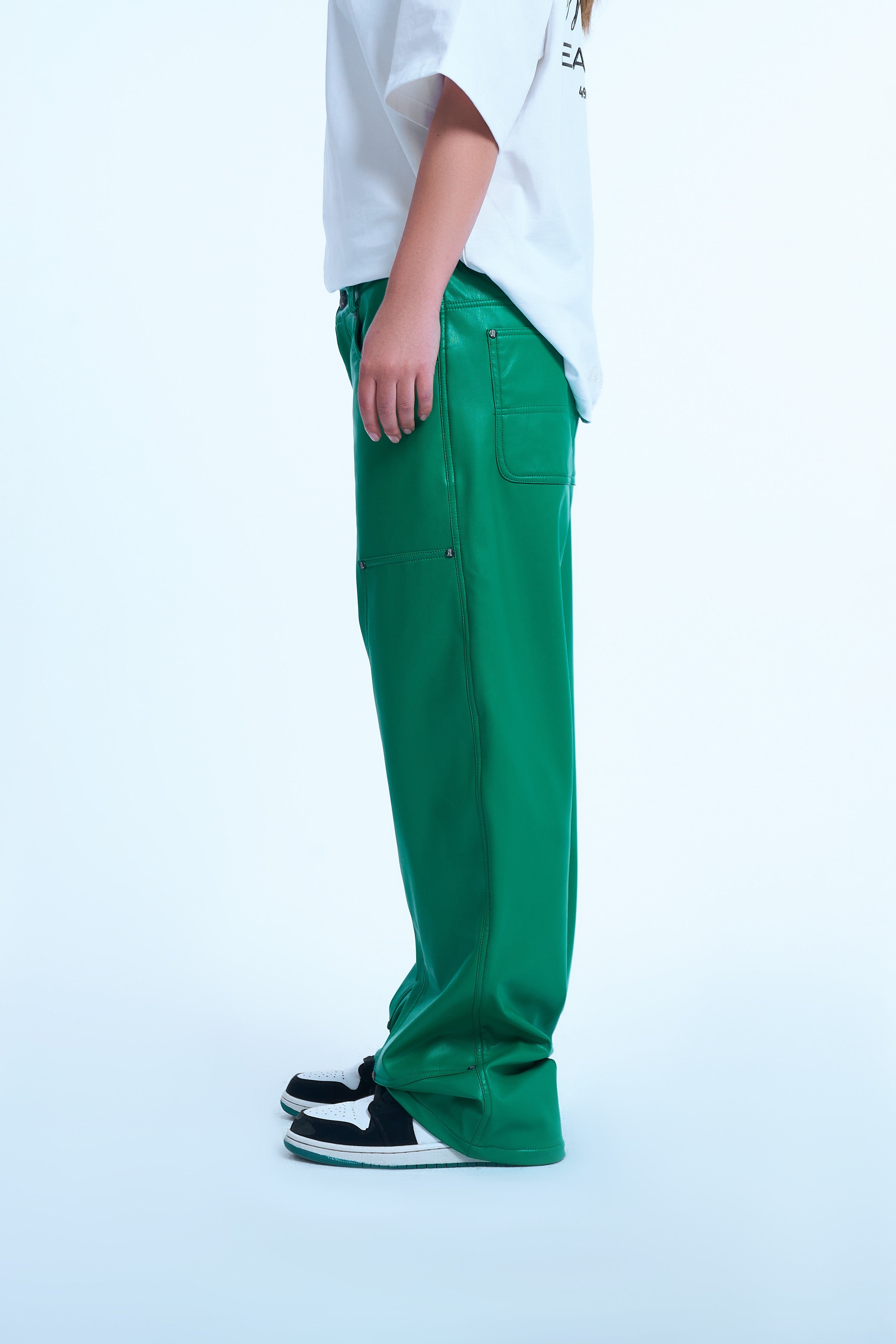 Gruene Carpenter Leather Pants von MOE CHARLIE, Seitenansicht weiblich, luftige weite Passform und Sneakers