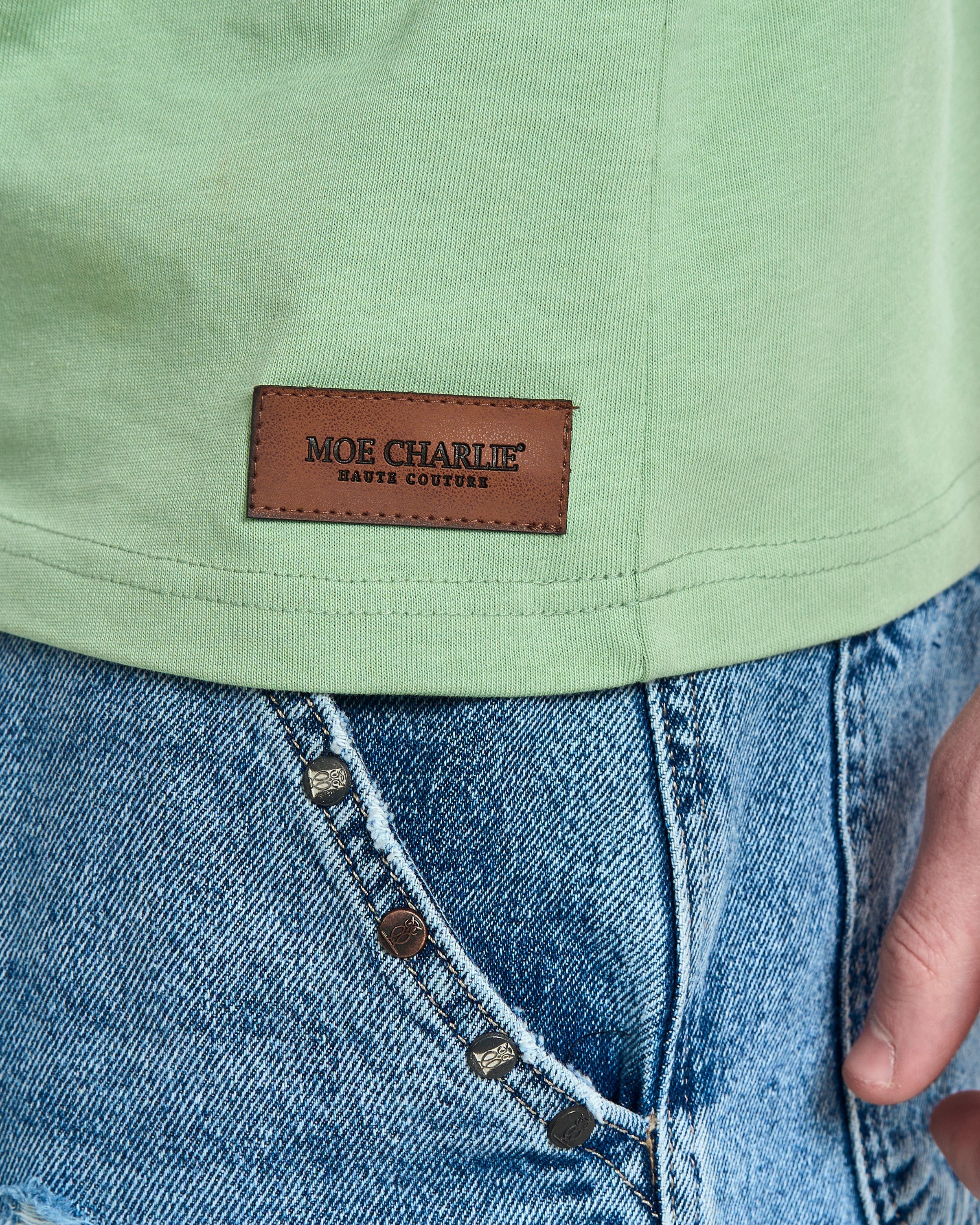Detailaufnahme Saum MOE CHARLIE Basic Tee Mintgrün – brauner Haute Couture Lederpatch auf mintfarbenem Stoff