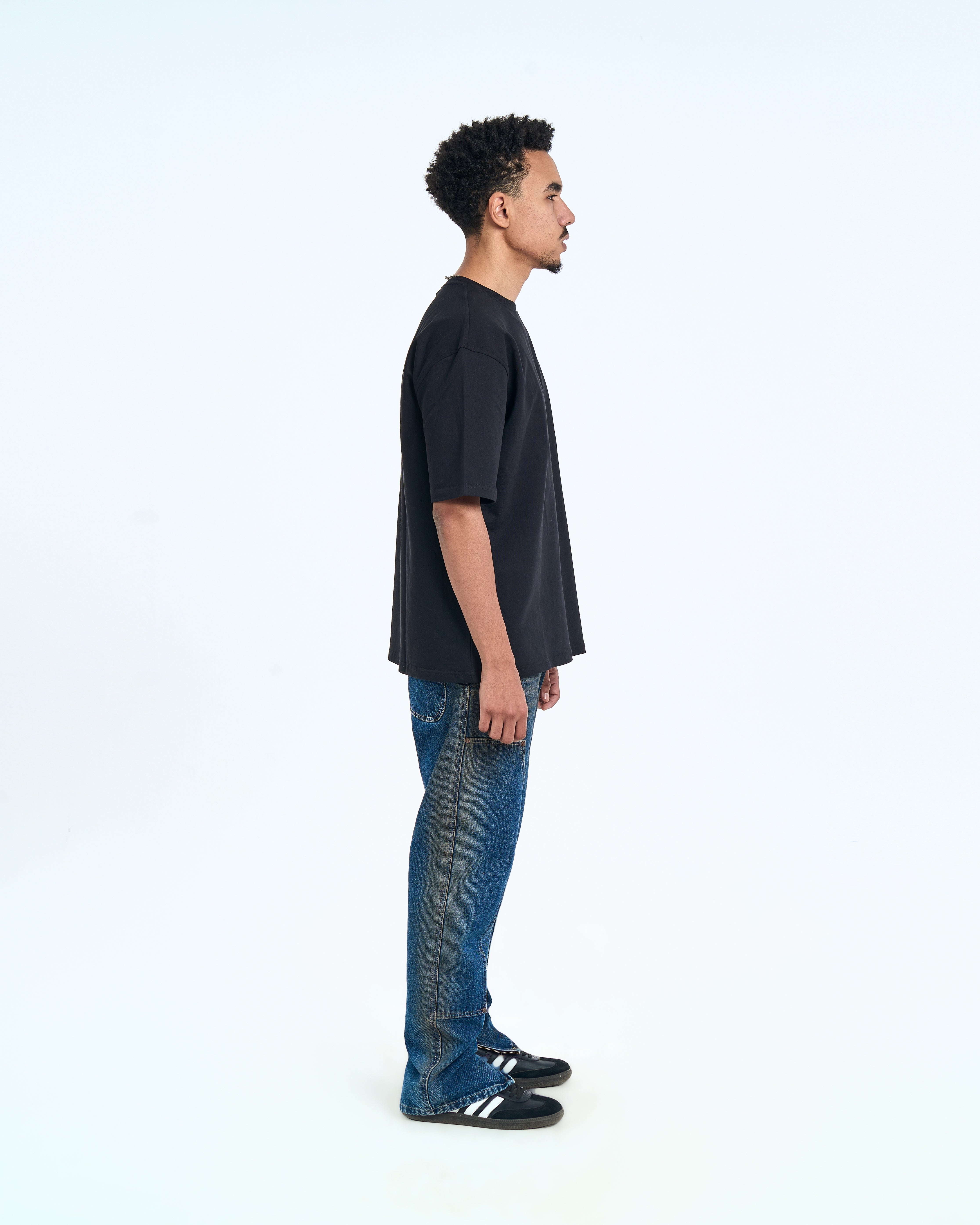 MOE CHARLIE Basic T-Shirt Schwarz – Seitenansicht rechts, Oversize-Silhouette, Herrenmodel mit blauen Jeans