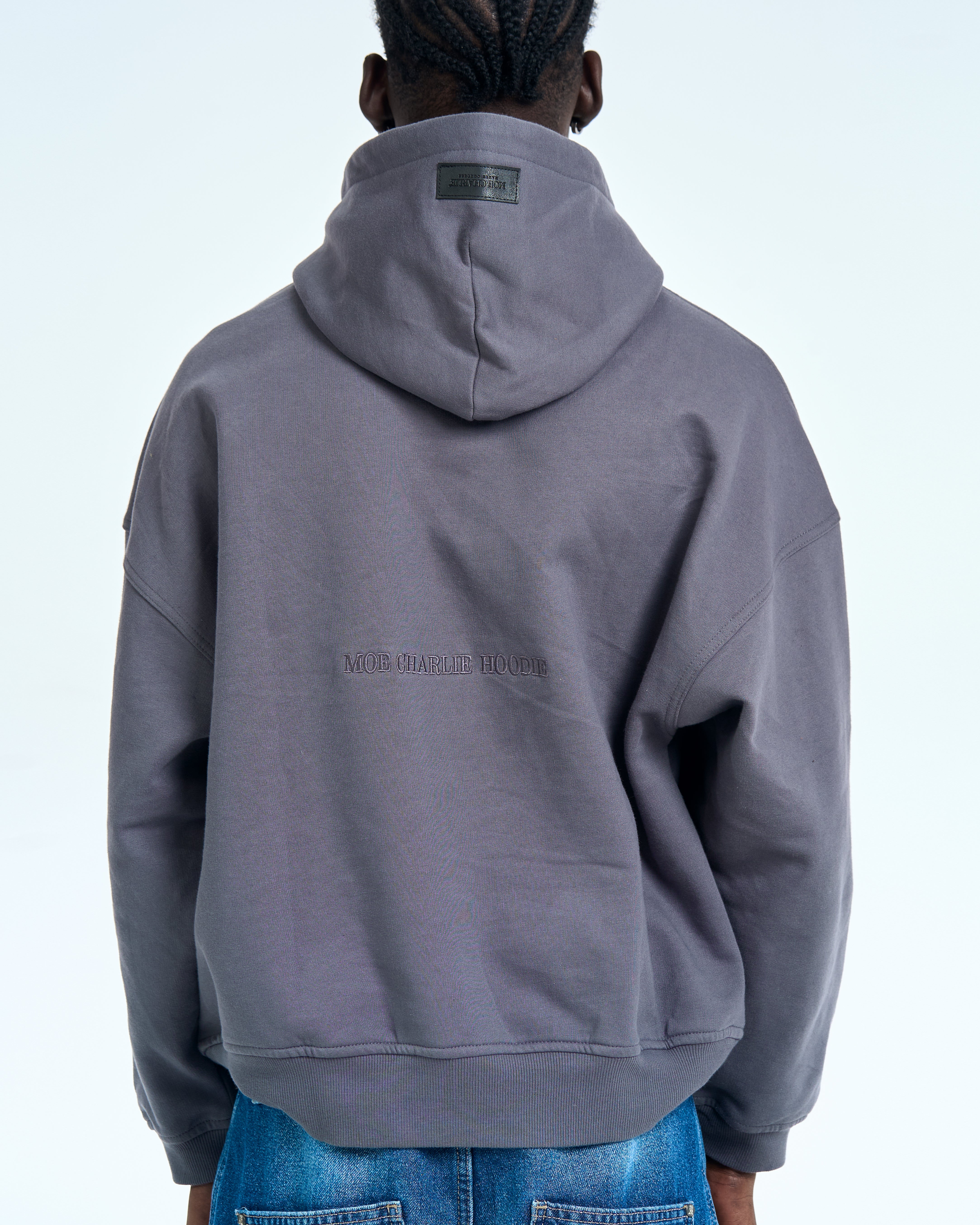 Born in Exile Hoodie Grau MOE CHARLIE, Rueckenansicht Ganzkoerper mit Kapuze und Leder-Label sichtbar
