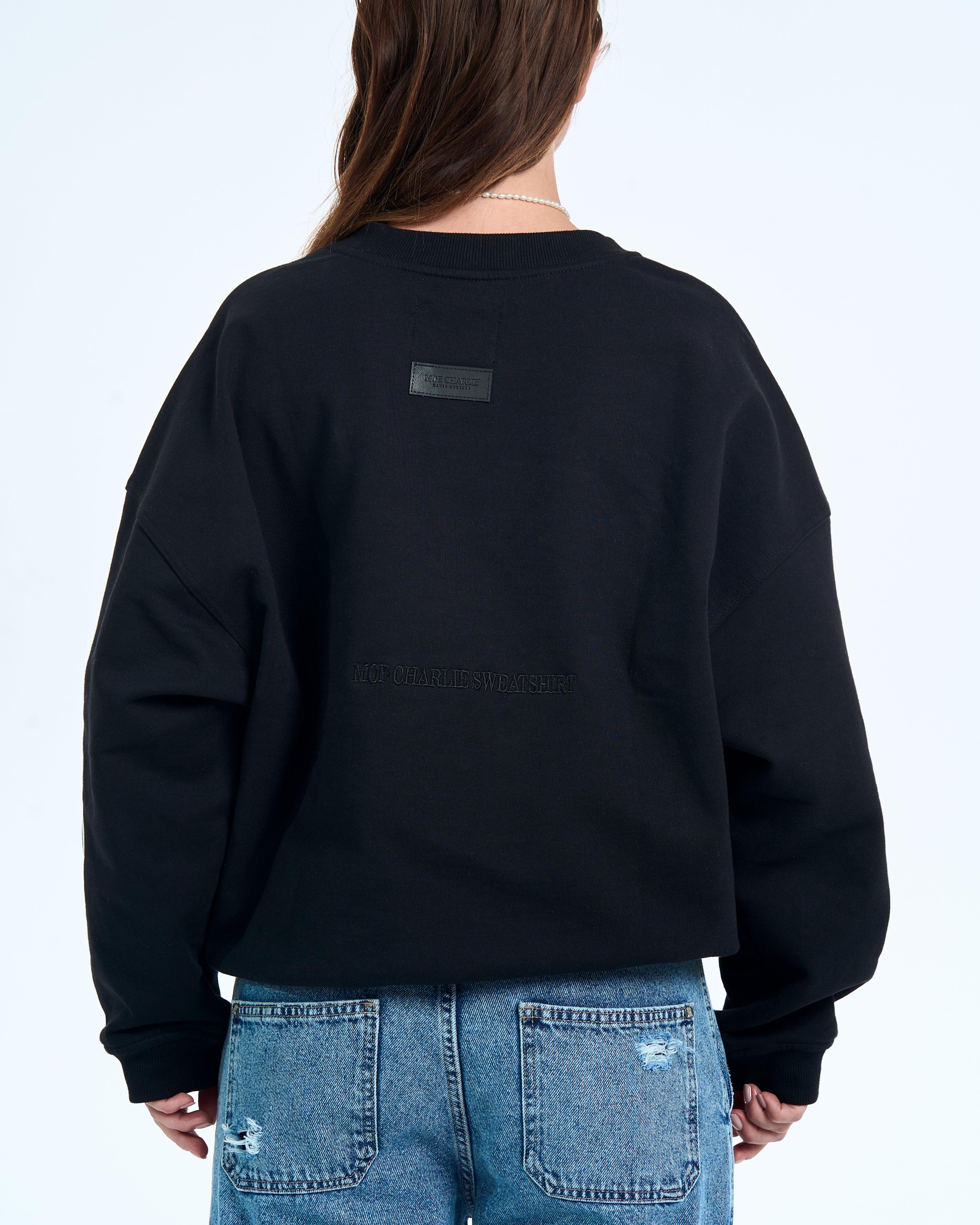 Ruecken-Detailaufnahme - Lederpatch und MOE CHARLIE SWEATSHIRT ton-in-ton Stickerei auf schwarzem Stoff