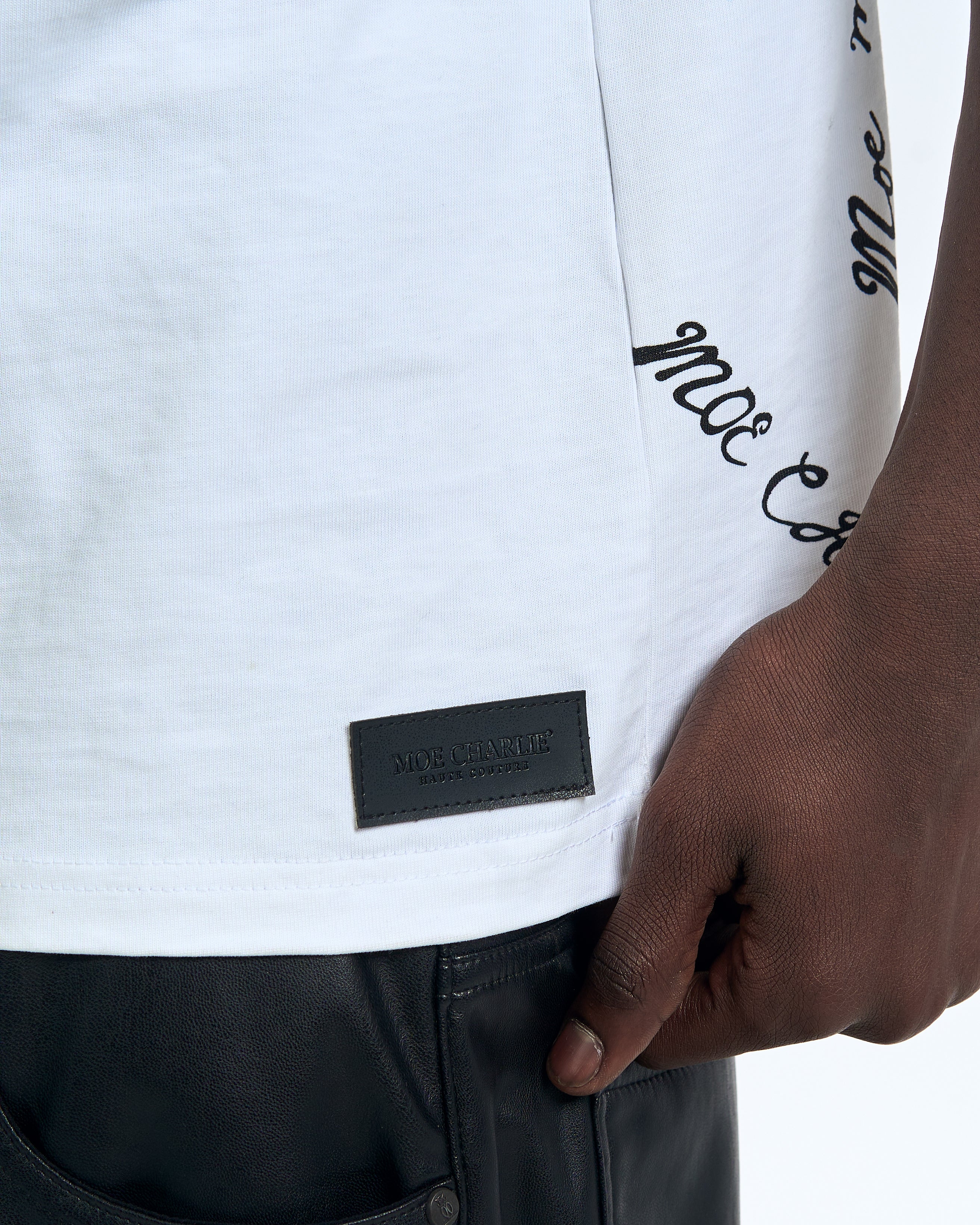 Detail Saumbereich MOE CHARLIE Self Made Shirt – schwarzes Haute Couture Leder-Patch und Script-Stickerei am Ärmel