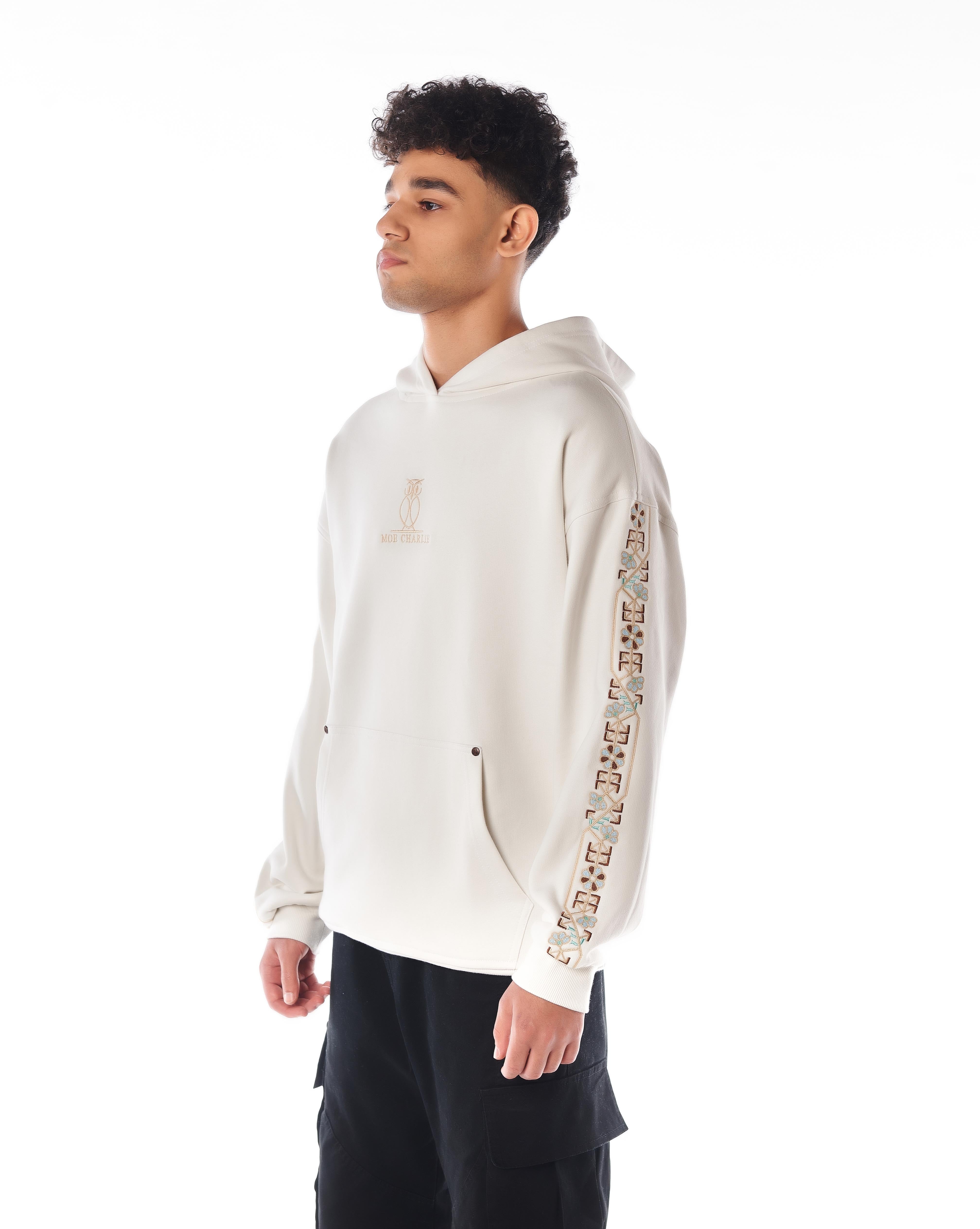 MOE CHARLIE Star White Hoodie, Ganzkörperpose leicht angewinkelt, Oversize-Silhouette mit floralem Ärmel