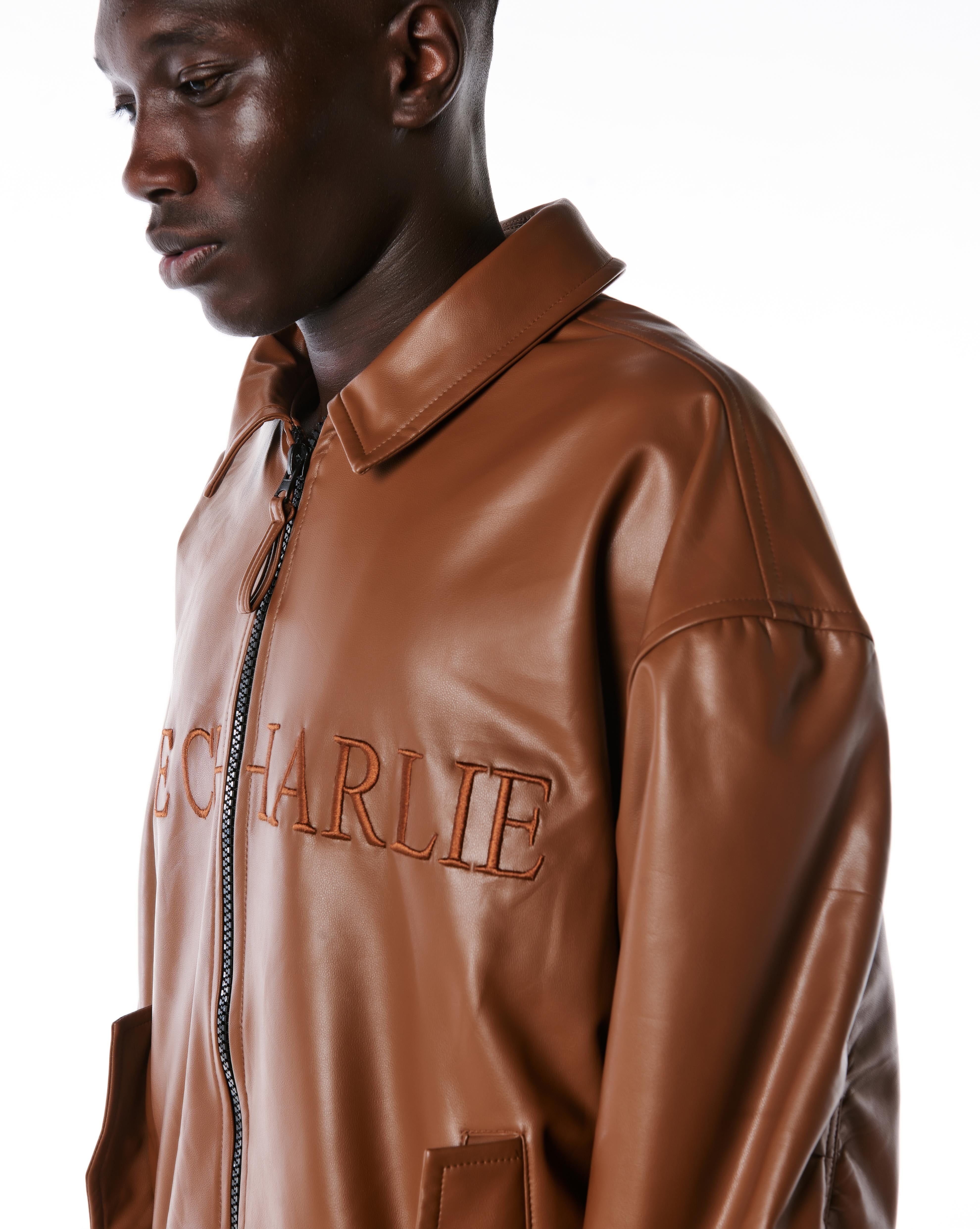 Dreiviertelansicht der MOE CHARLIE Lederjacke Braun, Stickerei auf der Brust seitlich sichtbar