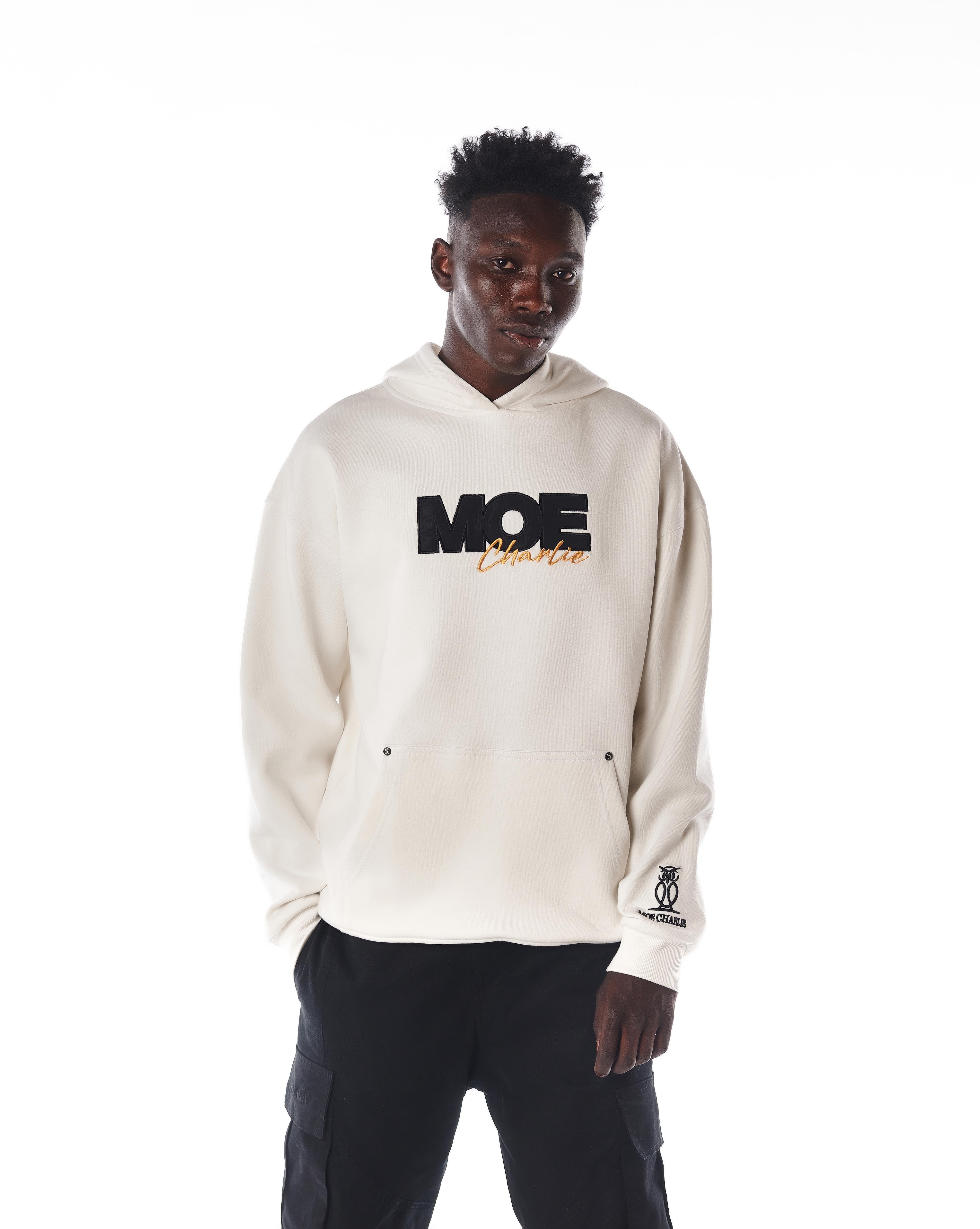 Halbkörper-Frontansicht MOE CHARLIE Gold Passion Hoodie, MOE-Stickerei und goldener Charlie-Schriftzug sichtbar