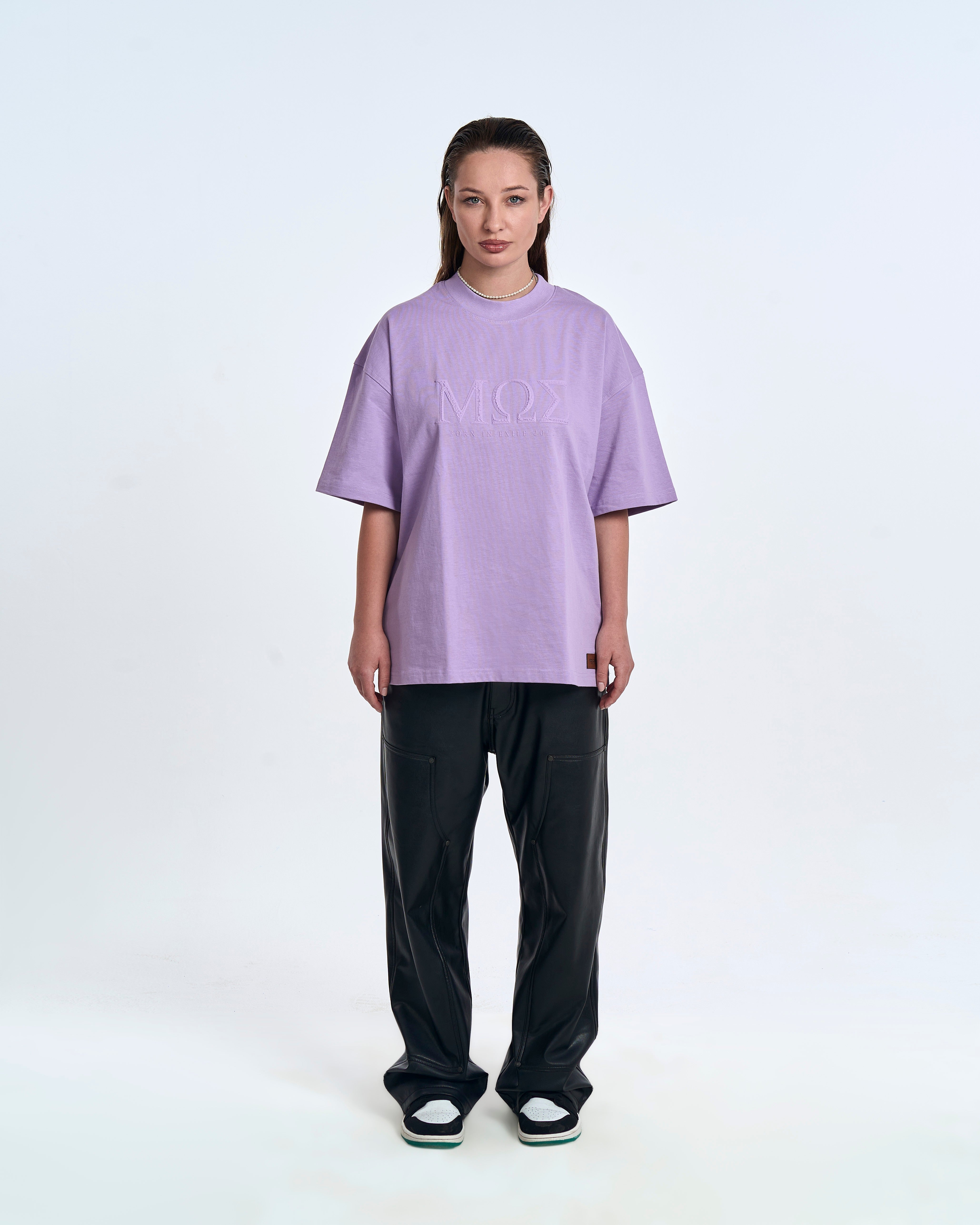 MOE CHARLIE Born In Exile T-Shirt Lavendel – Frontansicht Damenmodel, MΩΣ-Stickerei, schwarze Lederhose