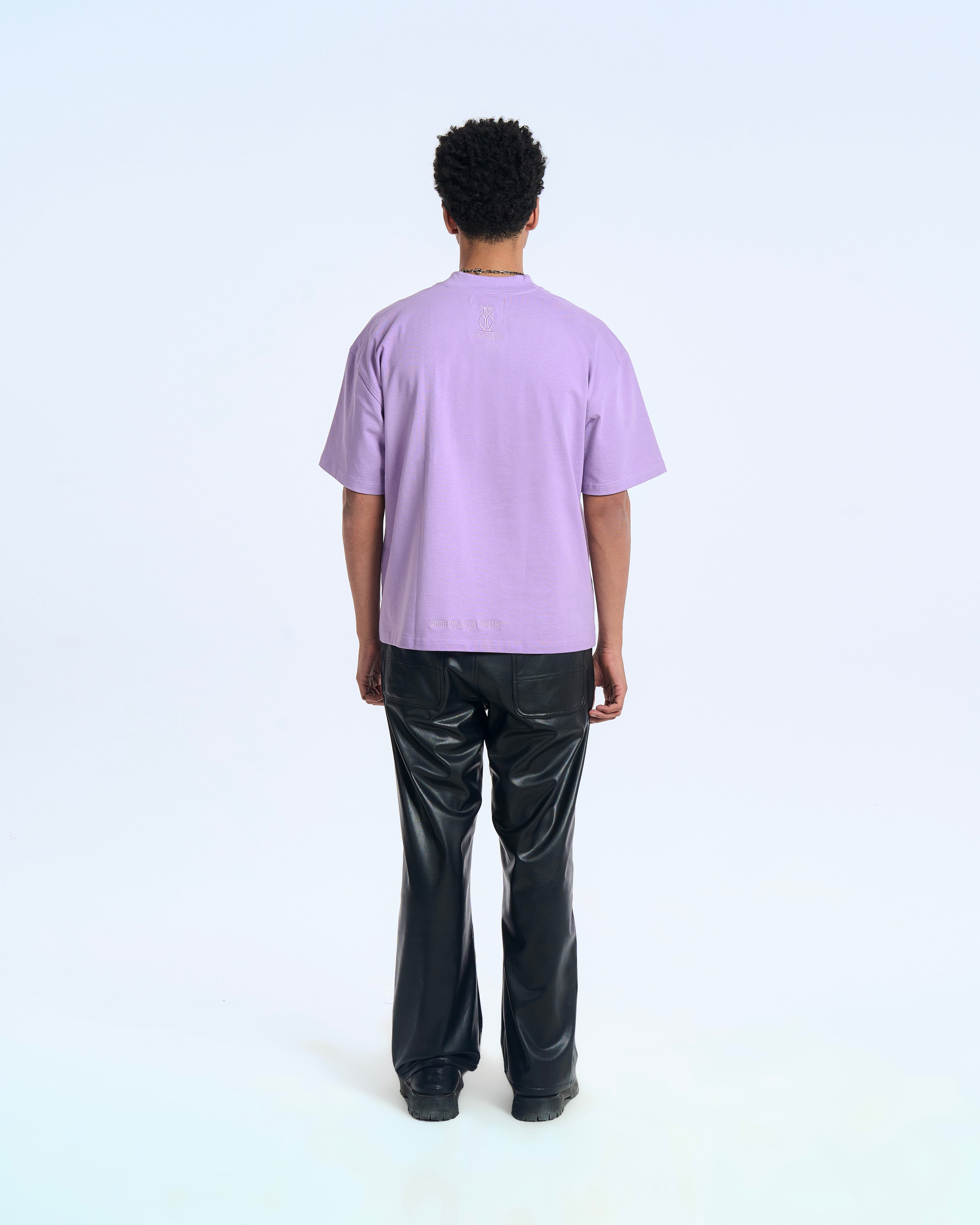 MOE CHARLIE Born In Exile T-Shirt Lavendel – Rückenansicht Herren, Eulen-Logo oben, Saum-Stickerei, Lederhose