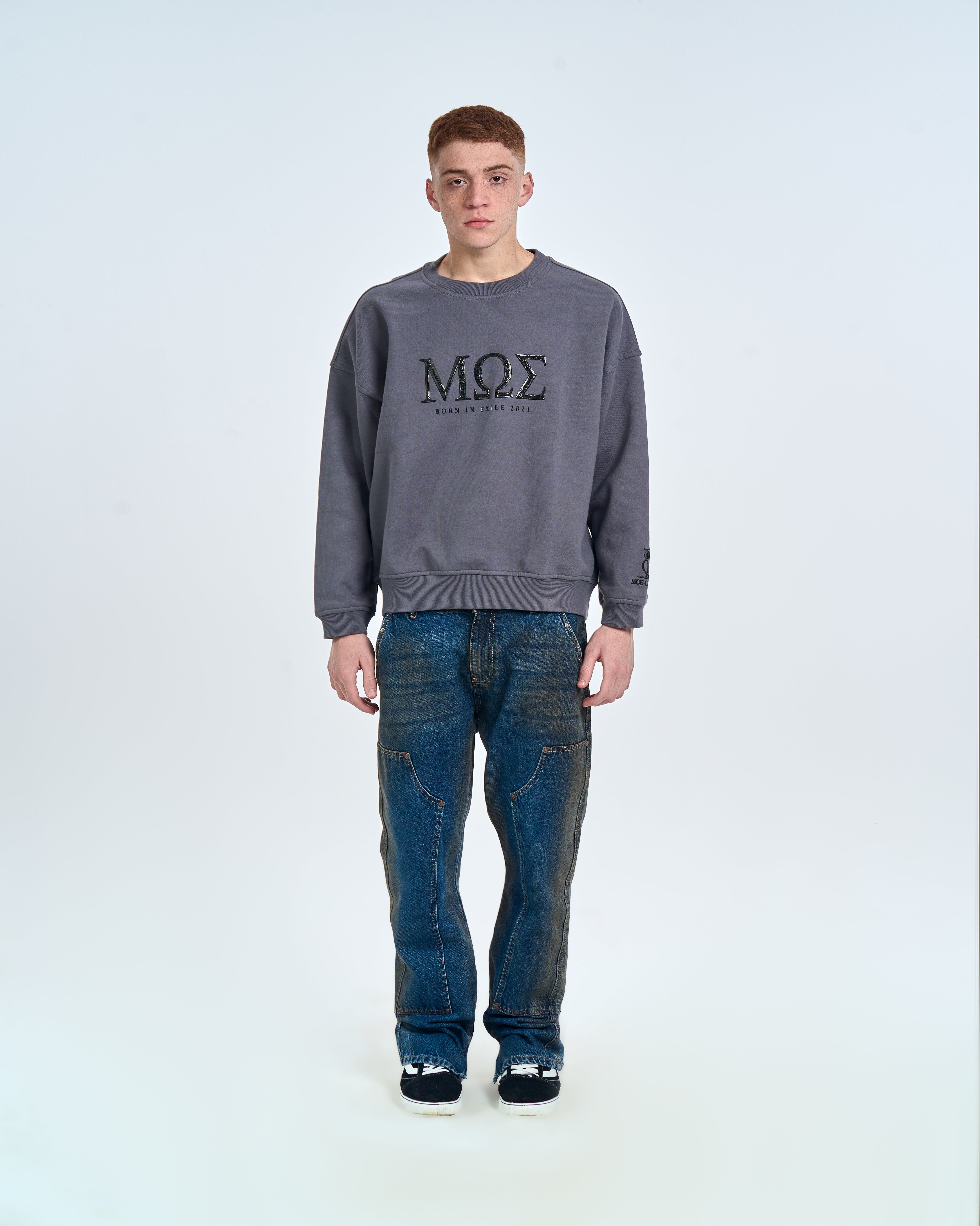 MOE CHARLIE Born in Exile Sweatshirt Grau, Frontansicht männlich, MΩΣ-Print, baggy Jeans und Sneakers
