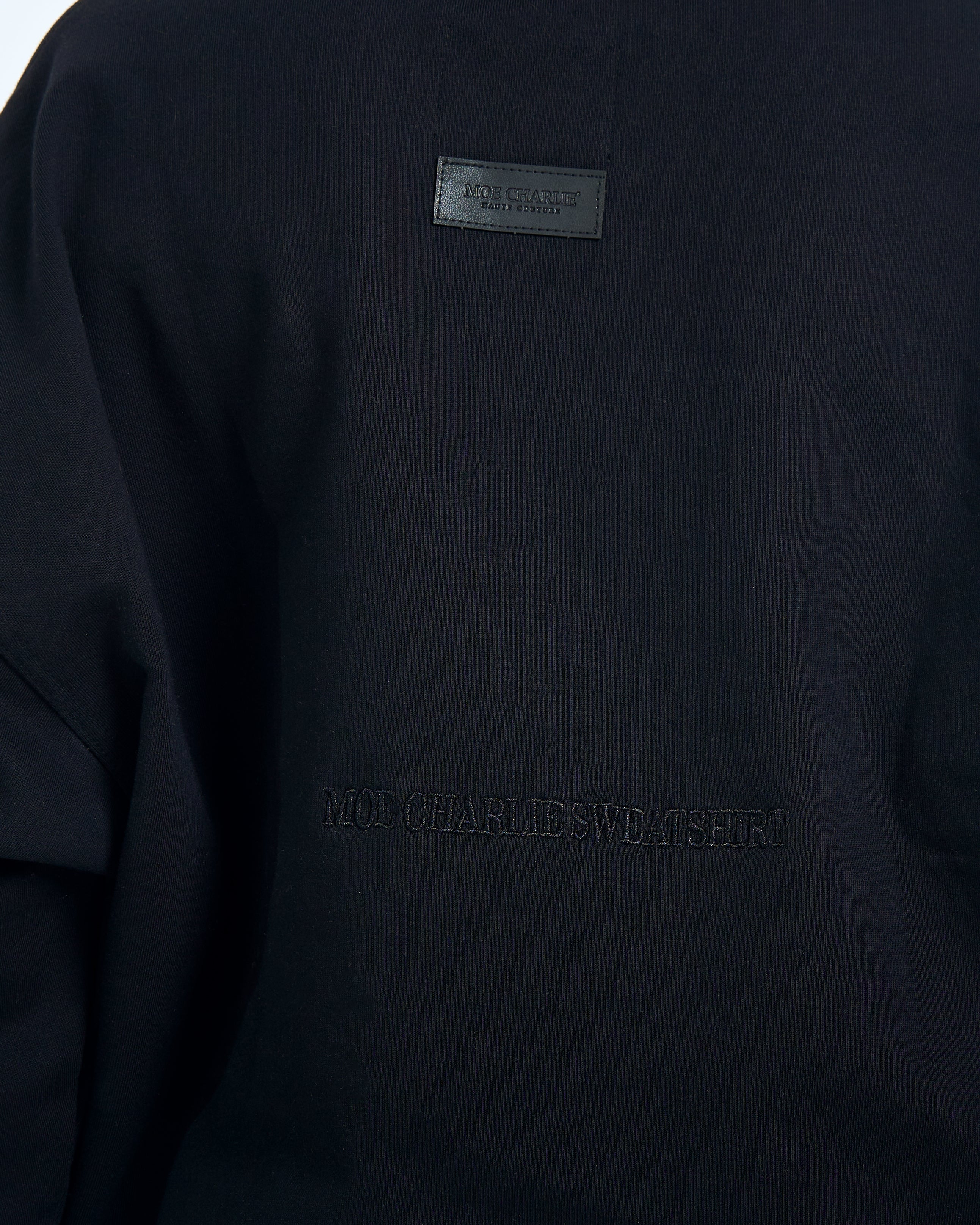Ruecken-Detailaufnahme - Lederpatch und MOE CHARLIE SWEATSHIRT ton-in-ton Stickerei auf schwarzem Stoff