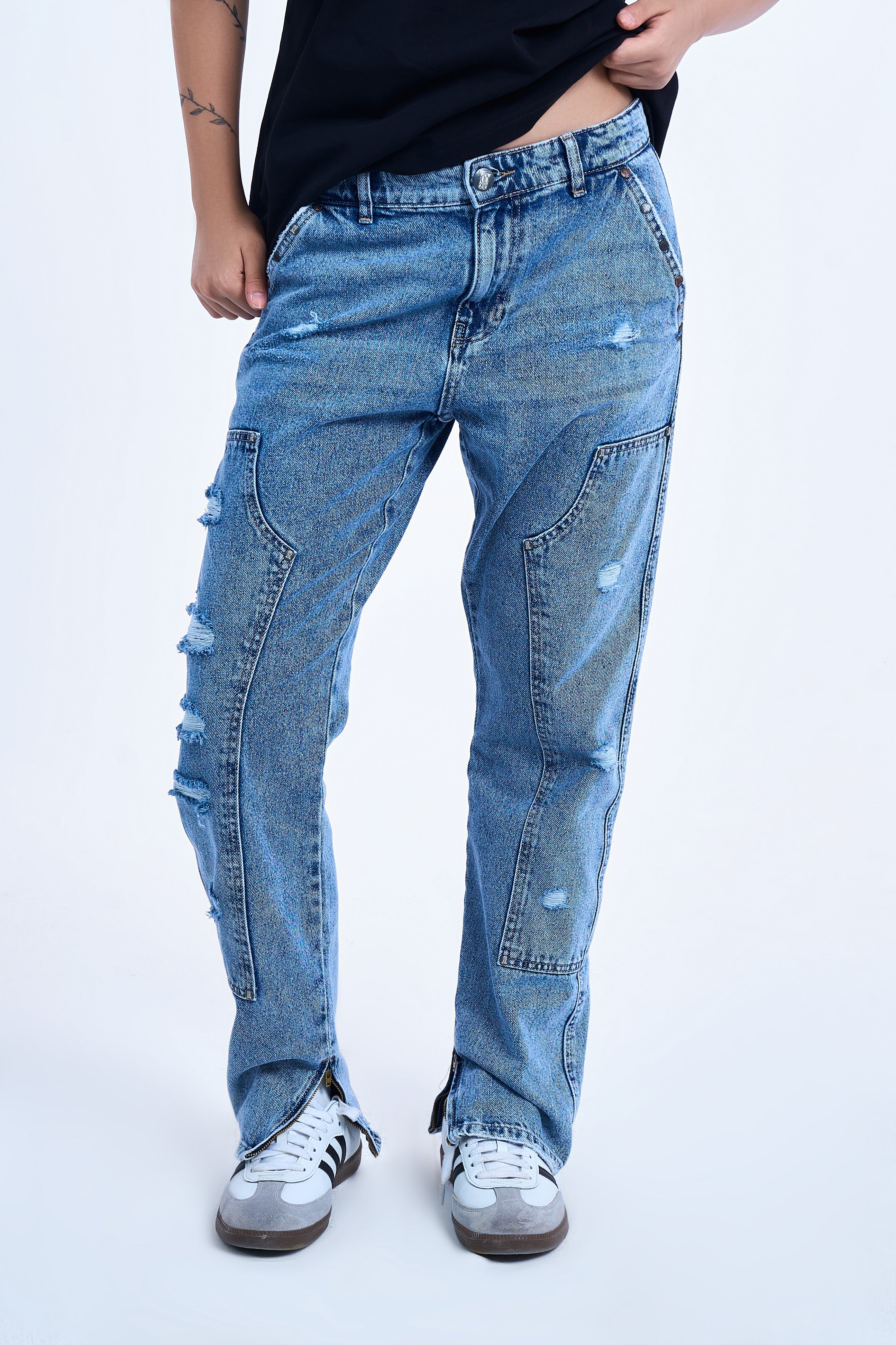 MOE CHARLIE Carpenter Flare Denim weiblicher Model – Frontansicht mit Utility-Saum-Zipper und Adidas Samba Sneakers