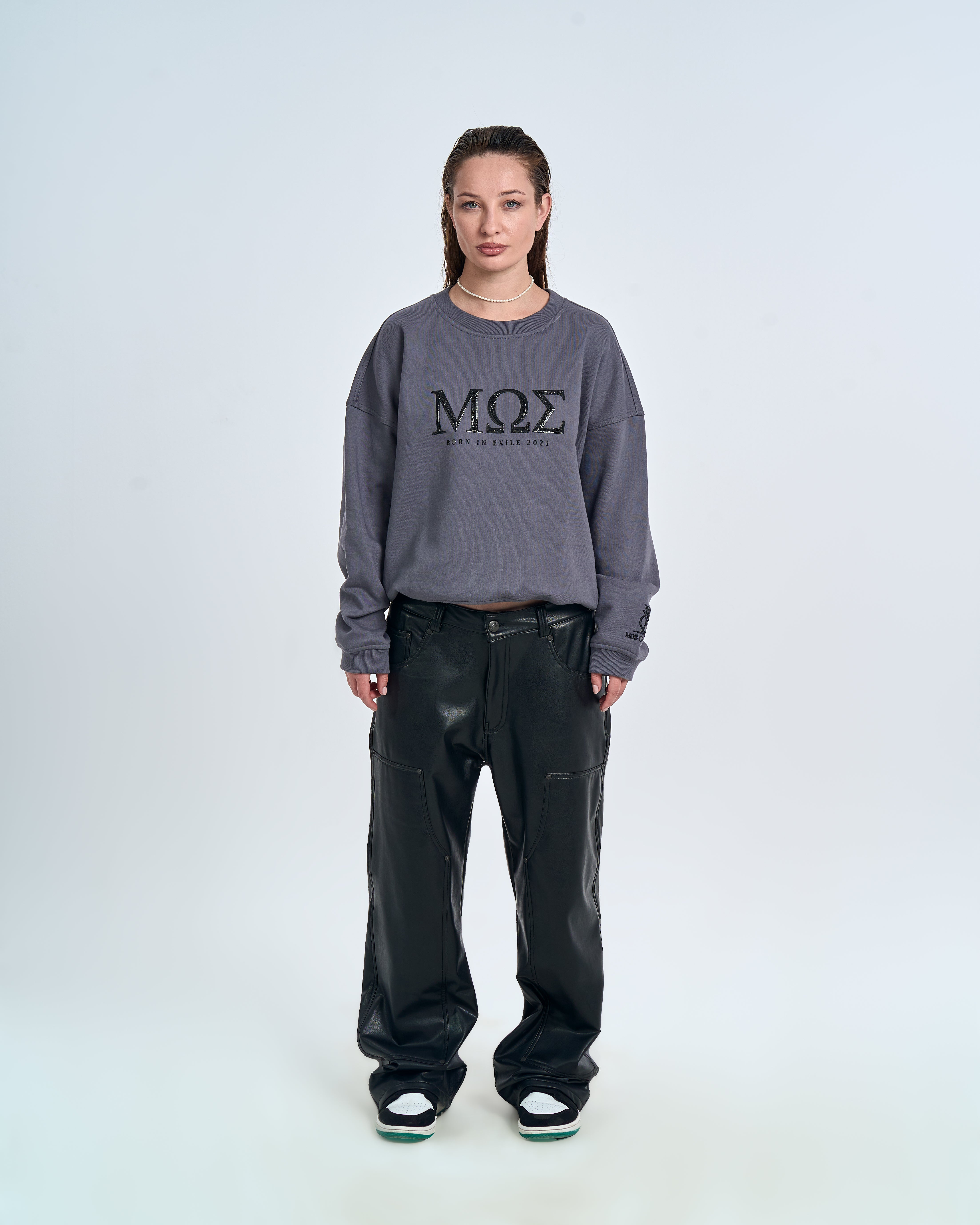 Born in Exile Sweatshirt MOE CHARLIE in Grau, Frontansicht weiblich, schwarze Lederhose und Perlenkette