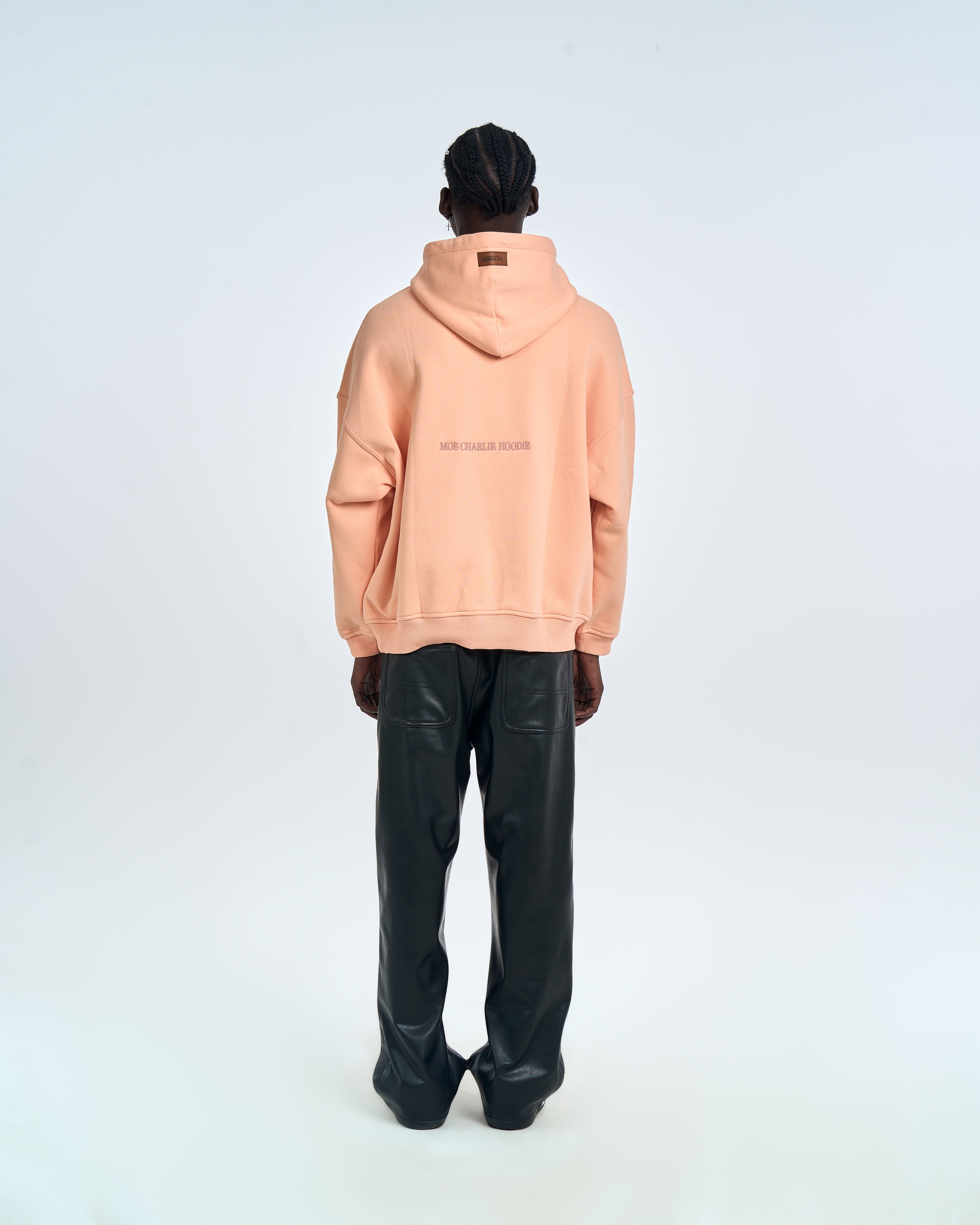 Rückenansicht Ready to Die Hoodie MOE CHARLIE in Peach, Schriftzug auf dem Rücken, schwarze Lederhose