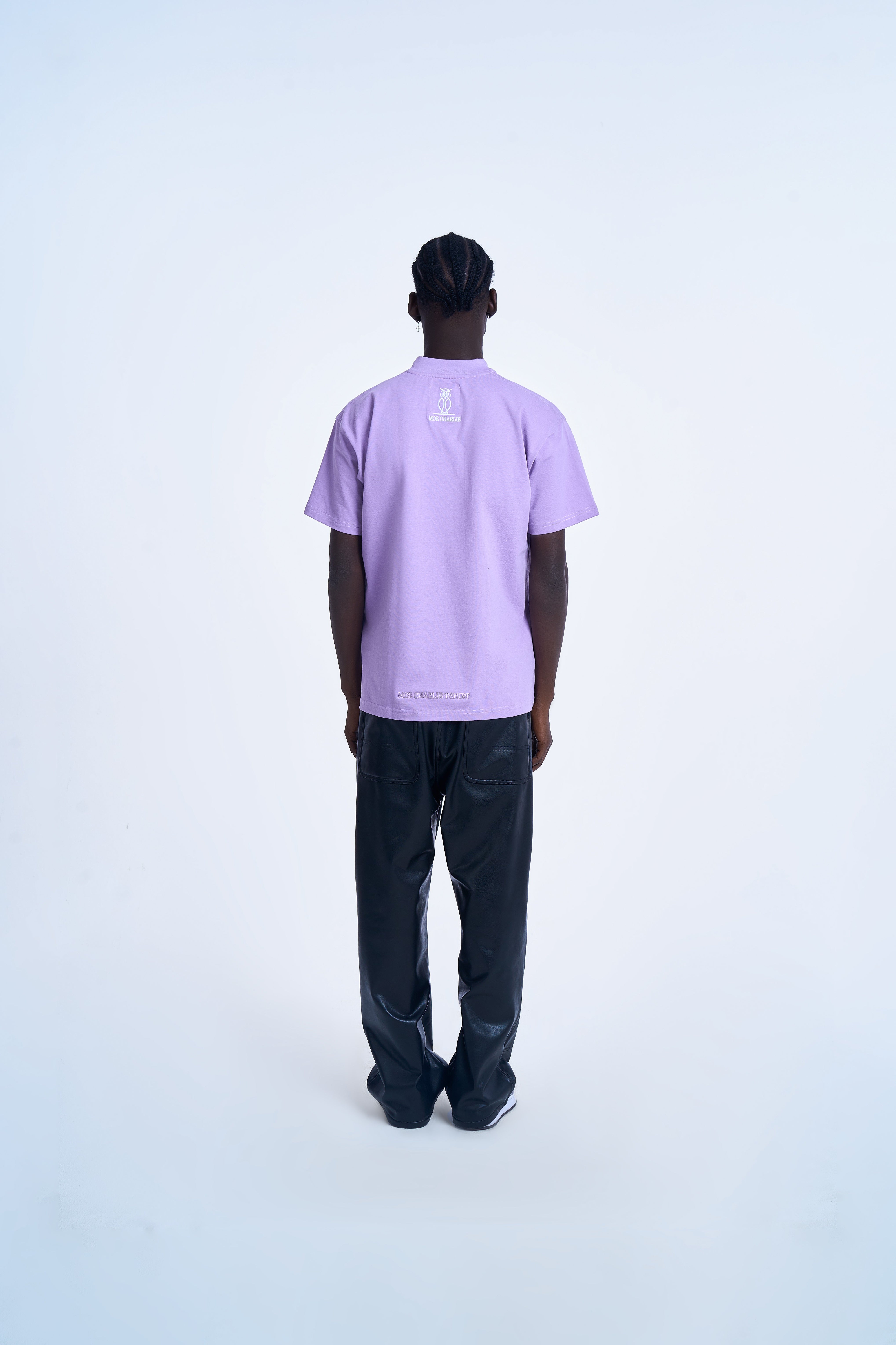 Rückenansicht MOE CHARLIE Basic T-Shirt Lavendel – kleines Eulen-Logo und Schriftzug in Weiß am Rücken, schwarze Pants