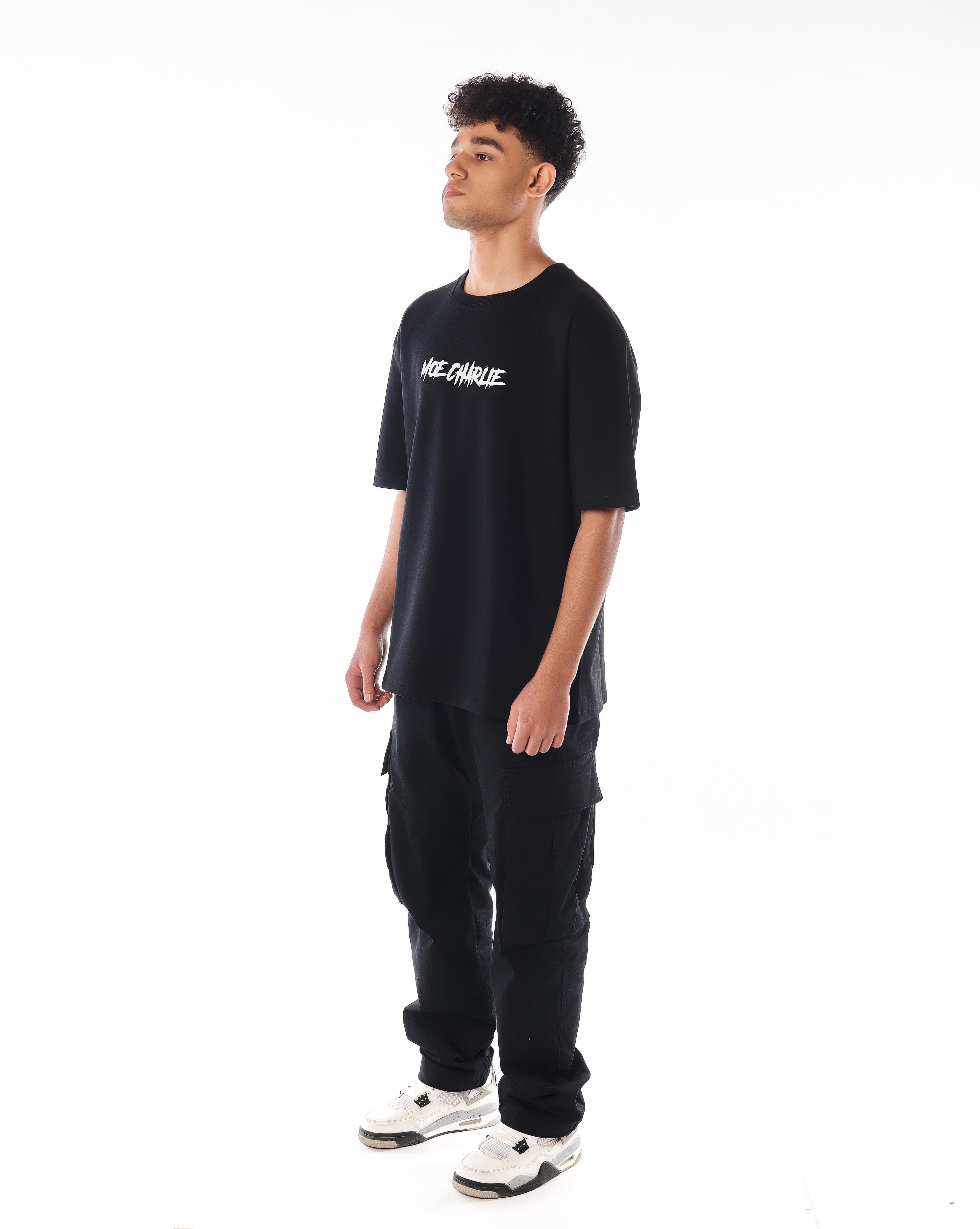 Dreiviertelansicht links MOE CHARLIE Predator T-Shirt, Frontprint seitlich, Oversize-Schnitt, Blick nach oben