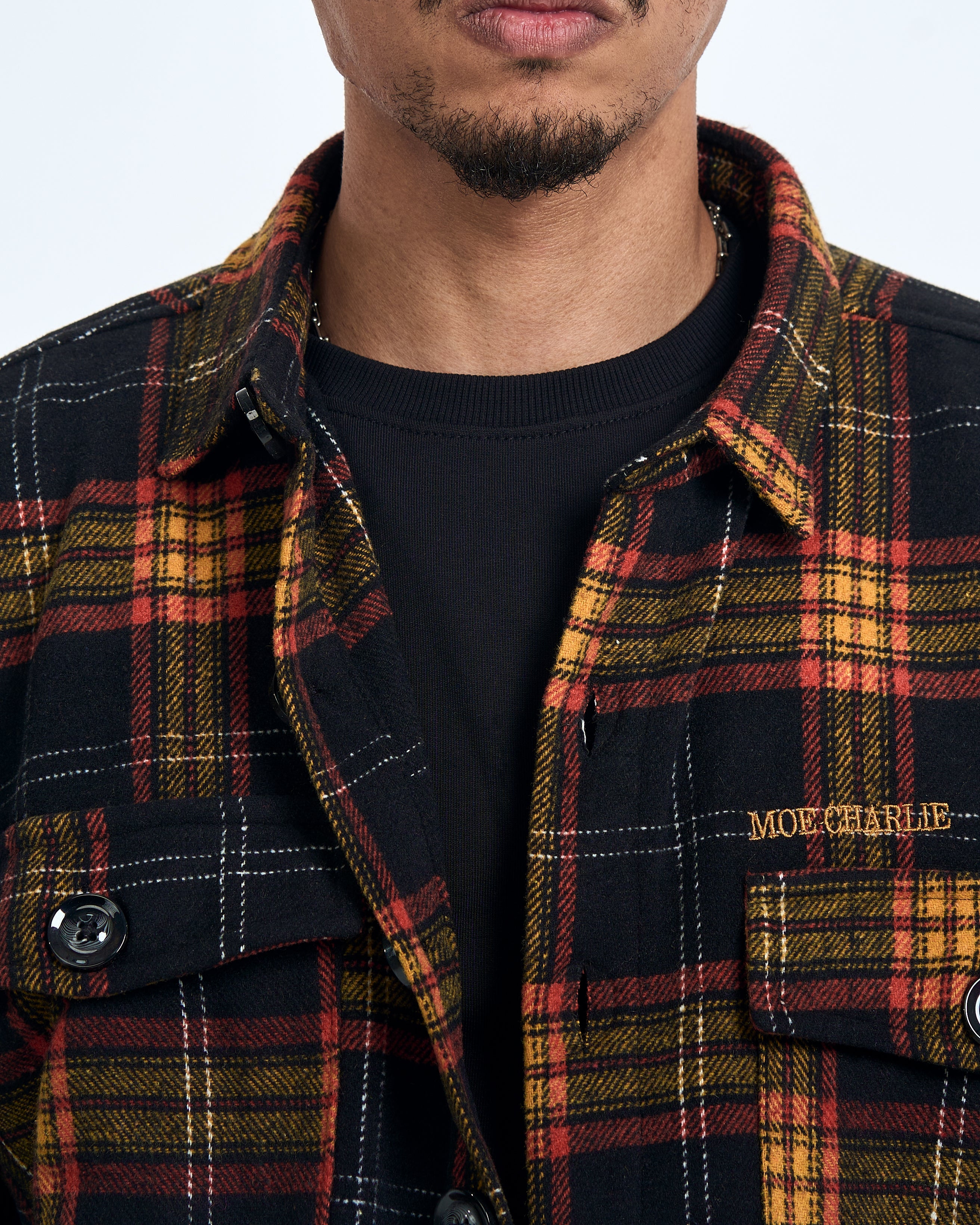 Nahaufnahme MOE CHARLIE Stickerei auf Brusttasche des Vintage Flannel Shirts, goldener Schriftzug
