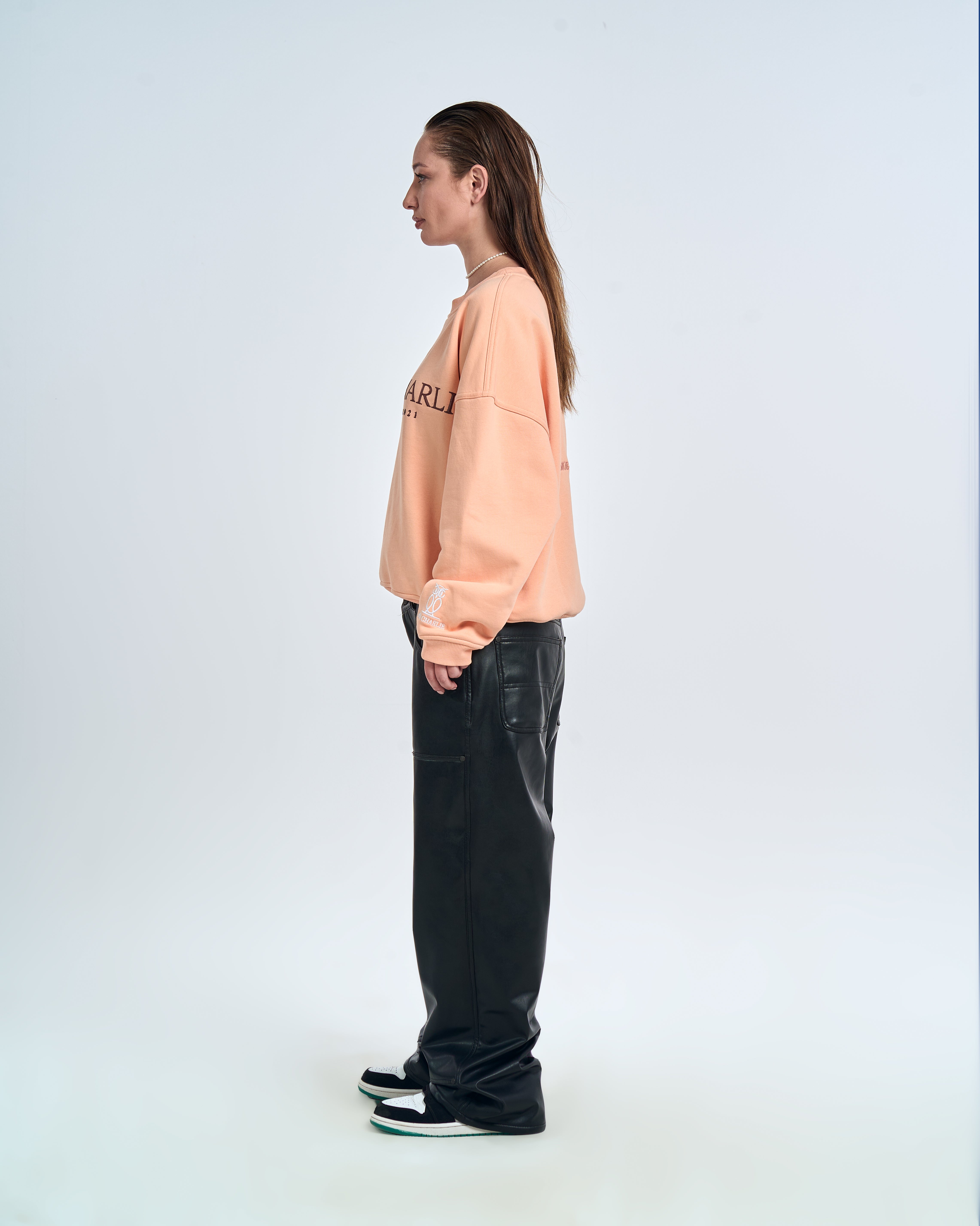 MOE CHARLIE Born In Exile Sweater Peach – Seitenansicht links Damen, Frontprint seitlich sichtbar, Lederhose