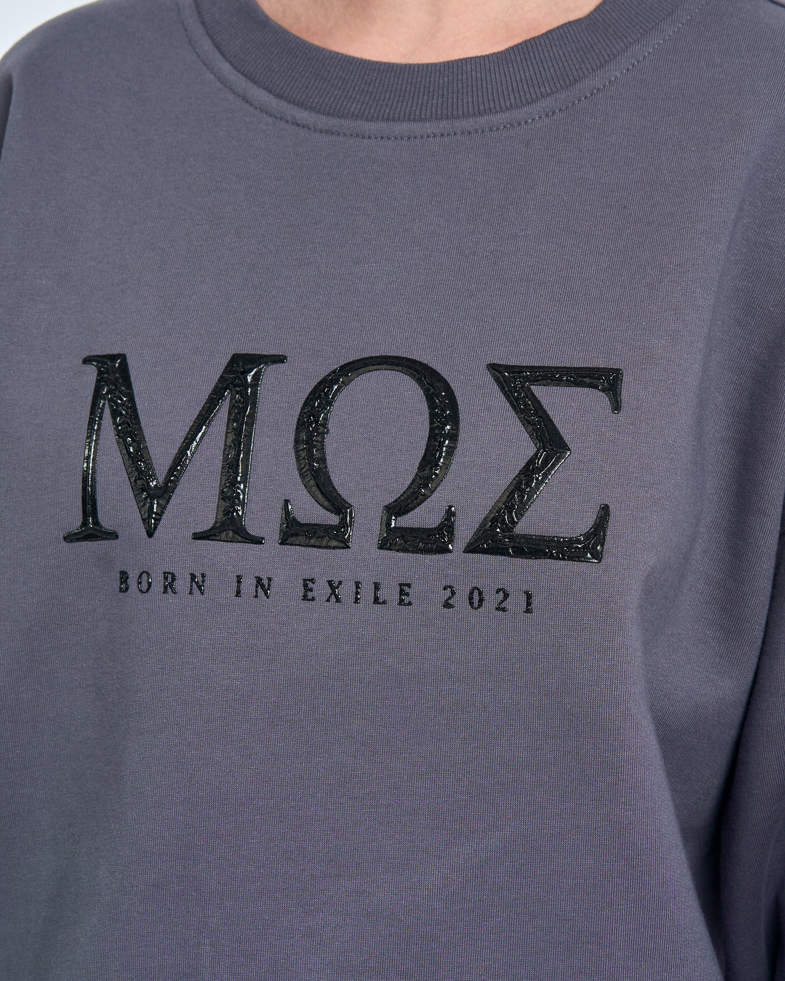 Detailaufnahme MΩΣ-Schriftzug Born in Exile 2021 auf MOE CHARLIE Sweatshirt Grau, Glanzoptik der Buchstaben