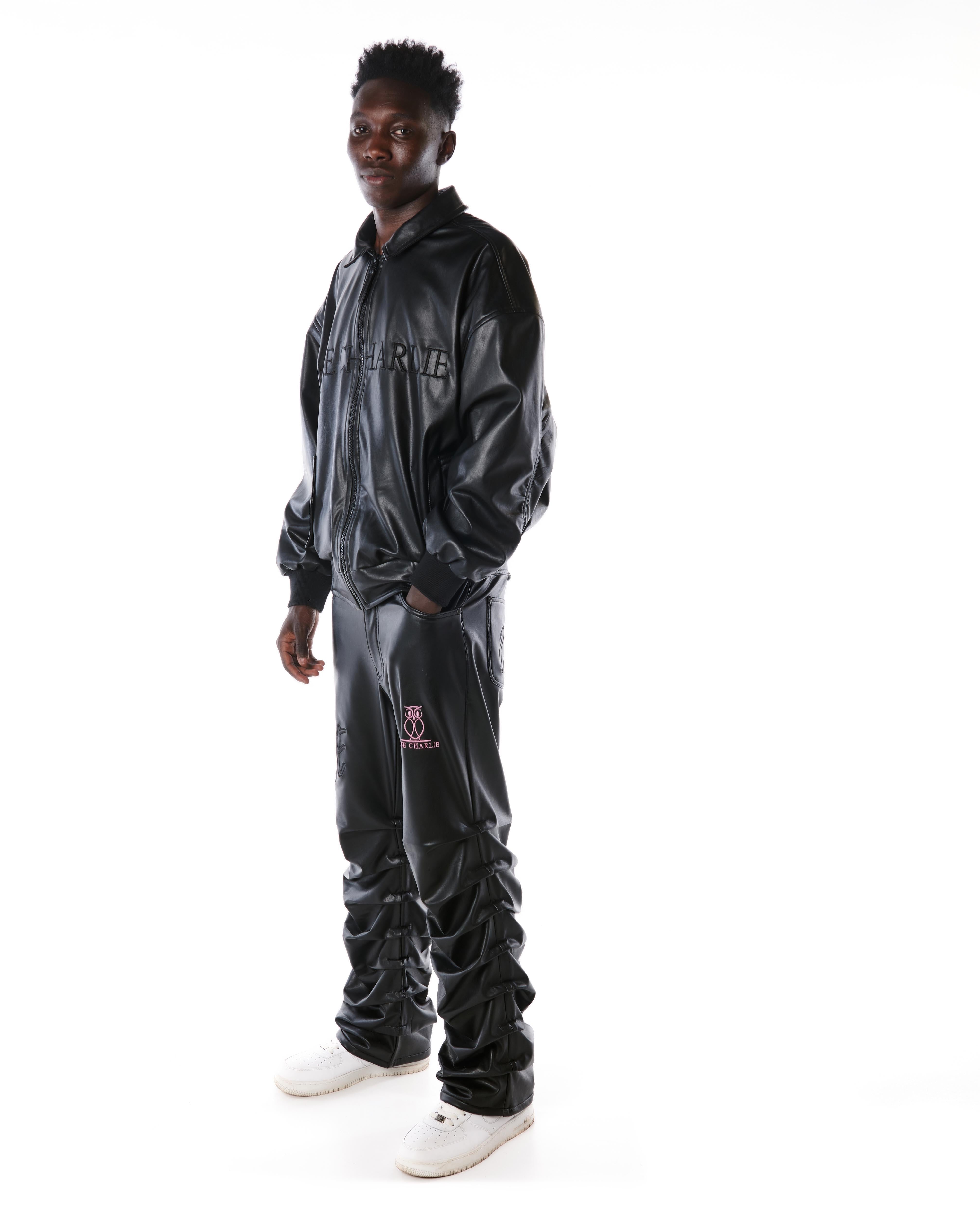 Dreiviertelansicht der MOE CHARLIE Lederhose Schwarz im Leather-Set, Jacke mit Schriftzug und Stacked-Hosenbein