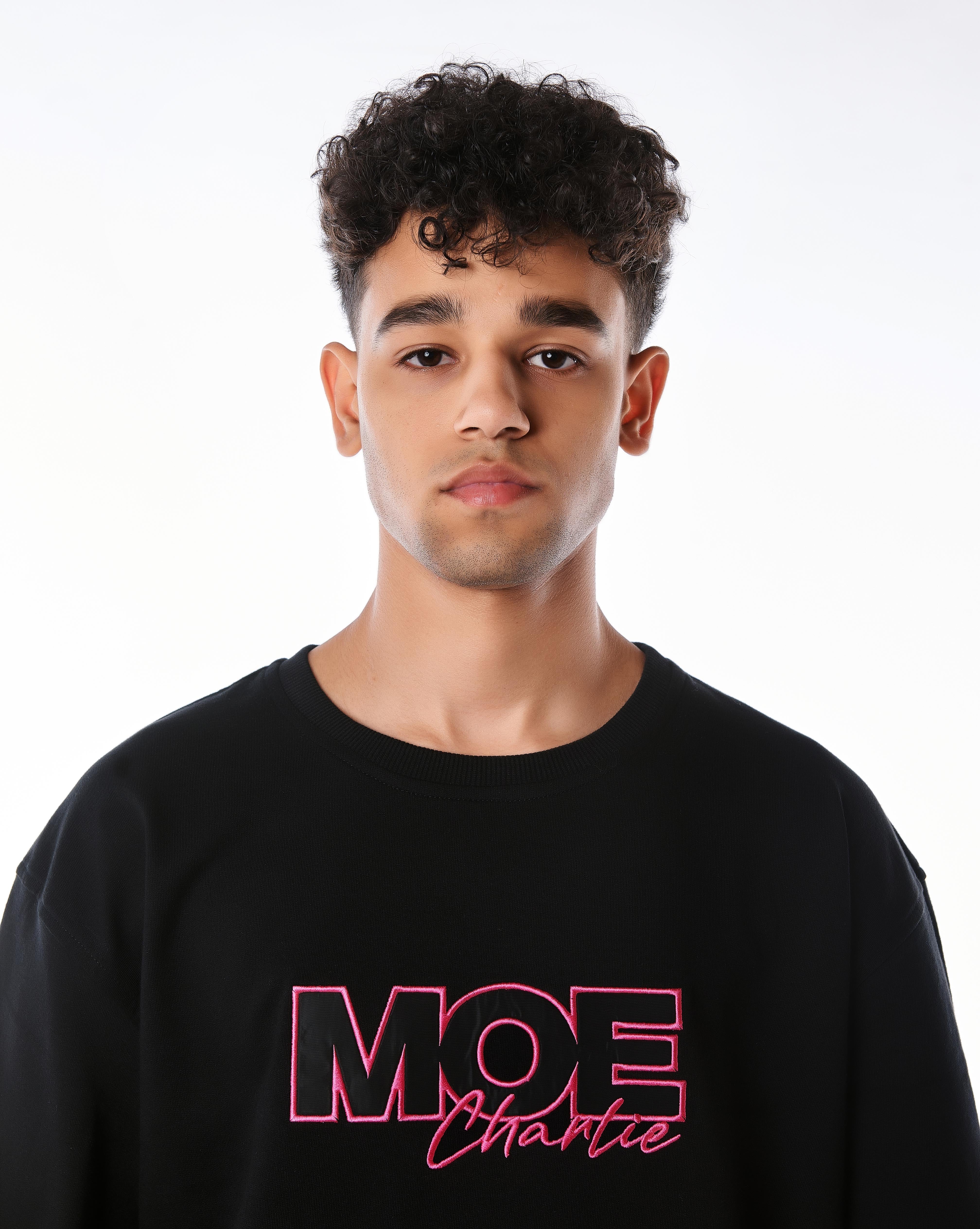Nahaufnahme Gesicht und Brust MOE CHARLIE Pink Passion T-Shirt, pinke MOE Charlie Stickerei zentral