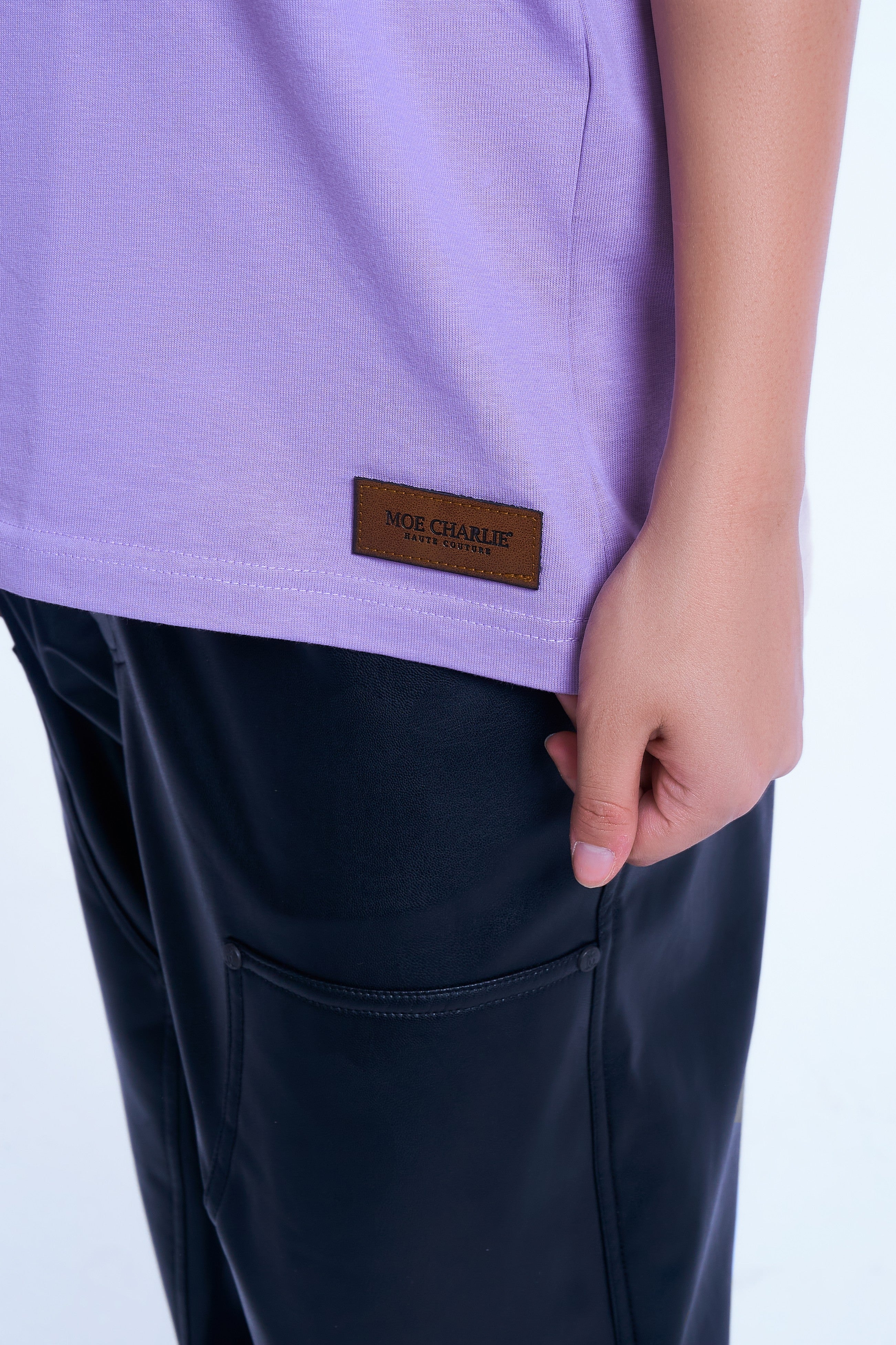 Detailaufnahme Saum MOE CHARLIE Basic T-Shirt – brauner Haute Couture Lederpatch auf Lavendel