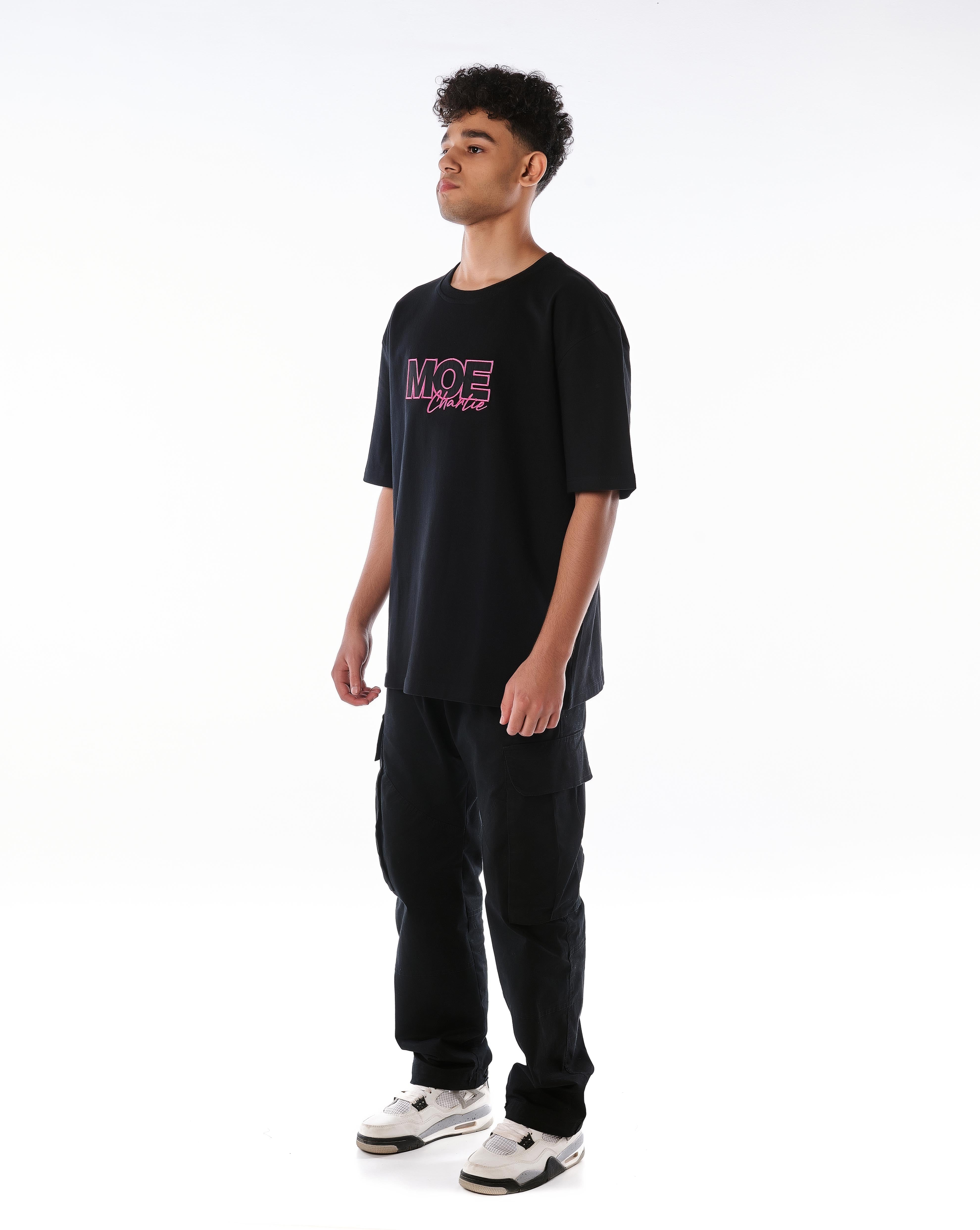 Dreiviertelansicht links MOE CHARLIE Pink Passion T-Shirt, Frontprint seitlich, Cargo-Hose und Sneakers