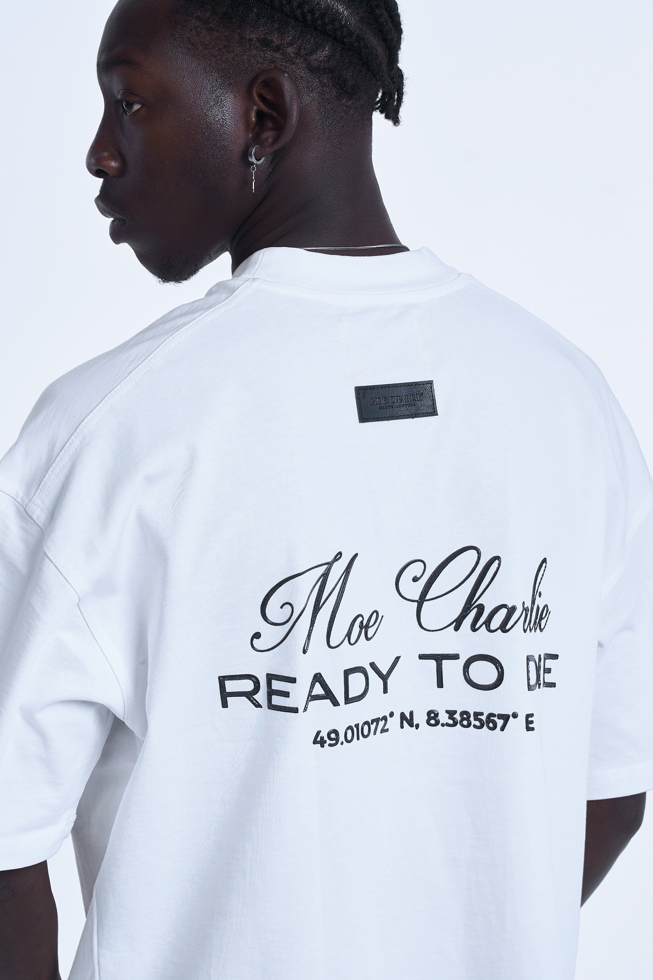 Nahaufnahme Rücken MOE CHARLIE Ready To Die Weiß – Haute Couture Label über Print, Koordinaten lesbar