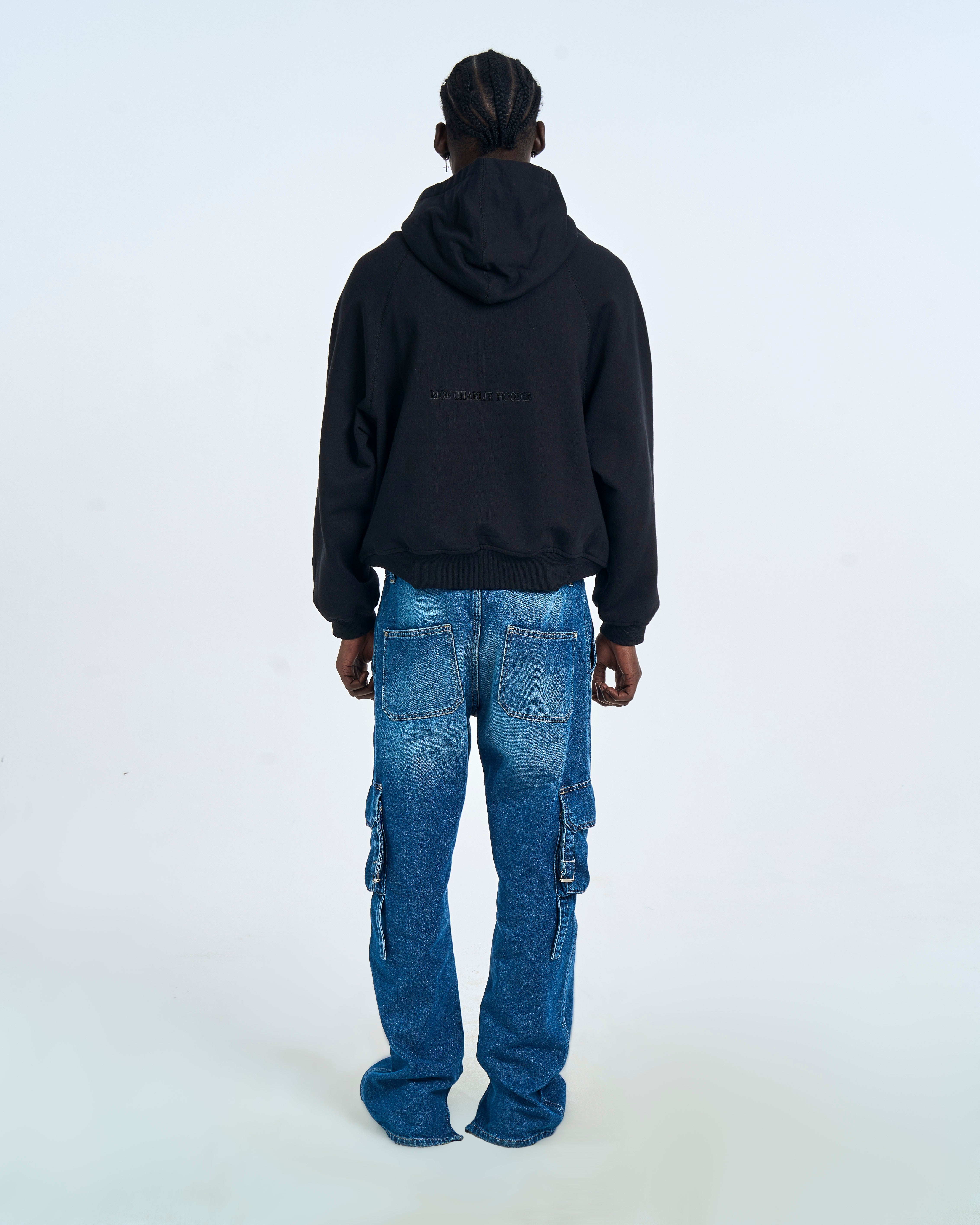 Rückenansicht MOE CHARLIE Cangaroo Hoodie Schwarz, diskreter Markentext auf dem Rücken, Cargo-Jeans