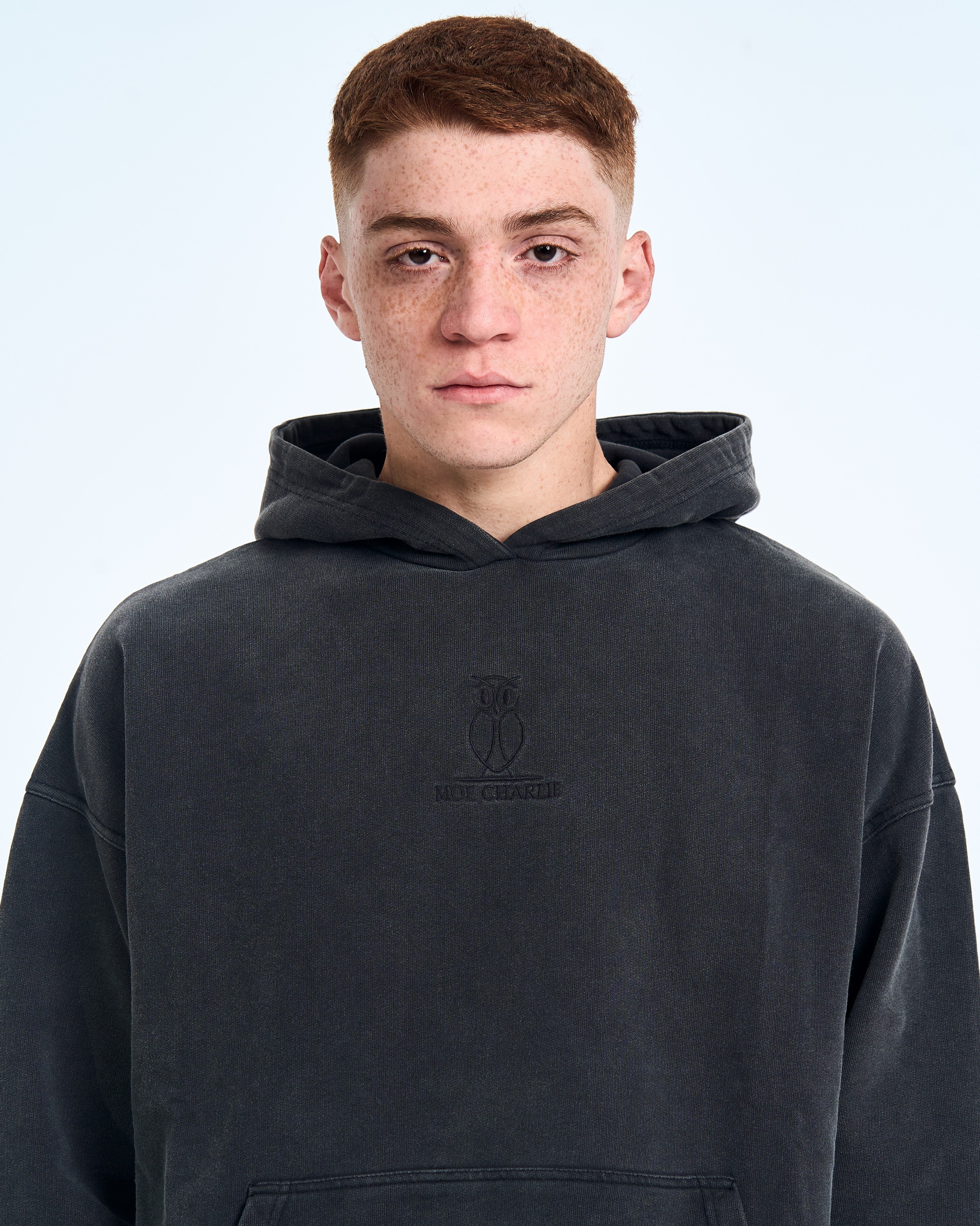 MOE CHARLIE Fade Out Hoodie, direkter Blick, Brustansicht mit Markenstickerei auf vintage-verwaschenem Stoff