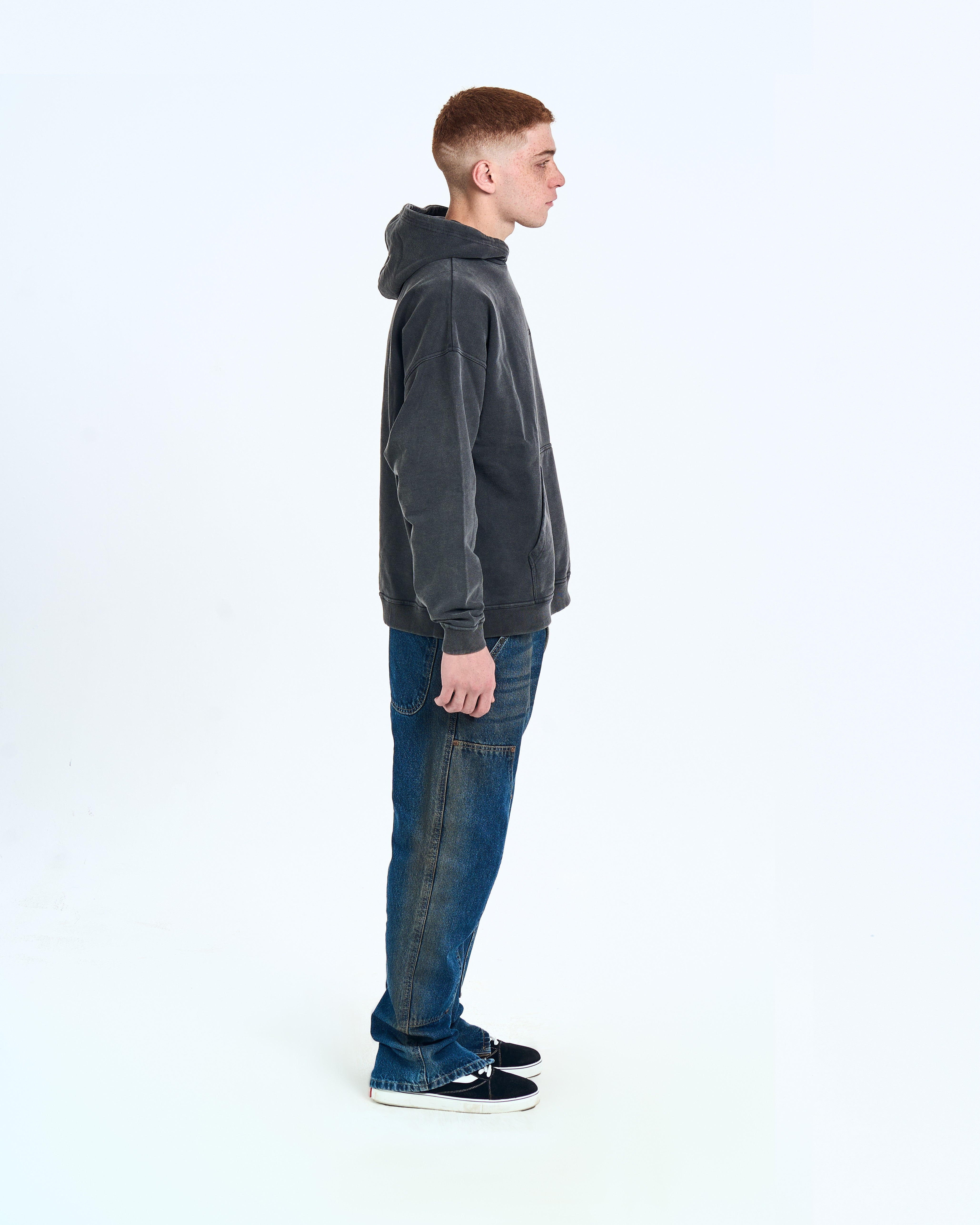 Seitenansicht MOE CHARLIE Hoodie Fade Out Black, verwaschene Optik im Seitenprofil, kombiniert mit Jeans