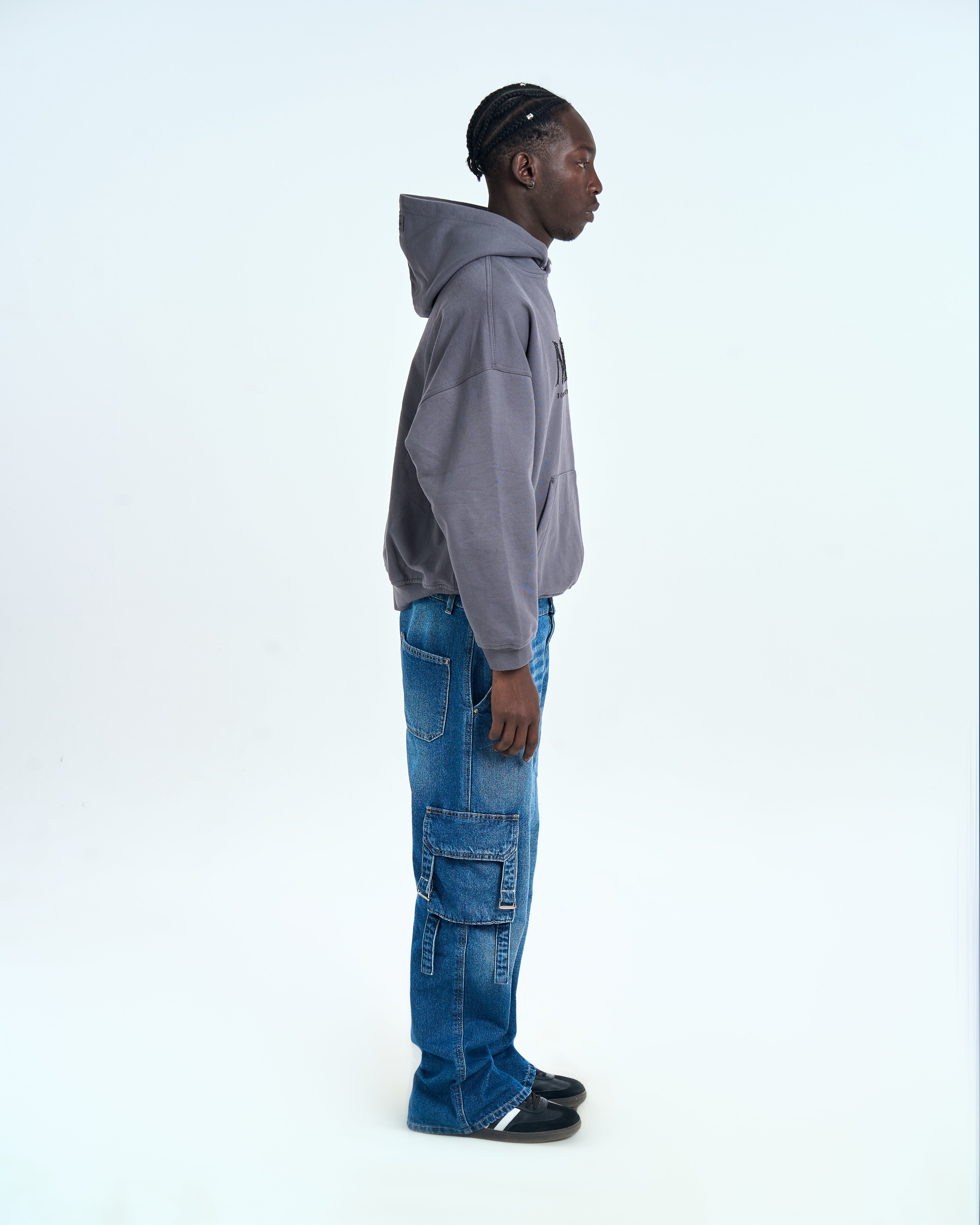 MOE CHARLIE Born in Exile Hoodie Grau, linke Seitenansicht mit Kapuze und Oversize-Silhouette, Cargo-Jeans