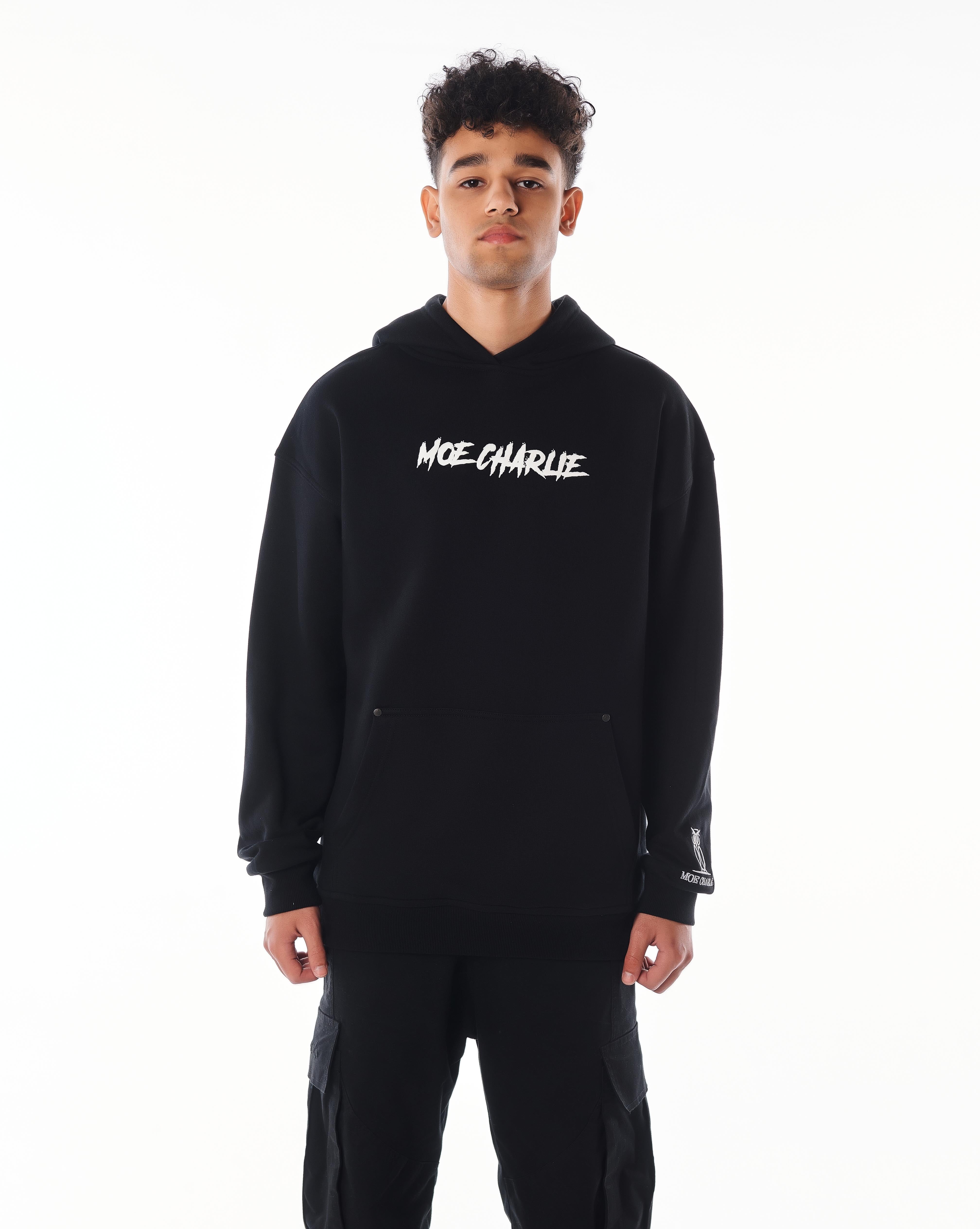 Ganzkörper-Frontansicht MOE CHARLIE Predator Hoodie, schwarzer Puff-Print auf Brust, Eulen-Label am Handgelenk